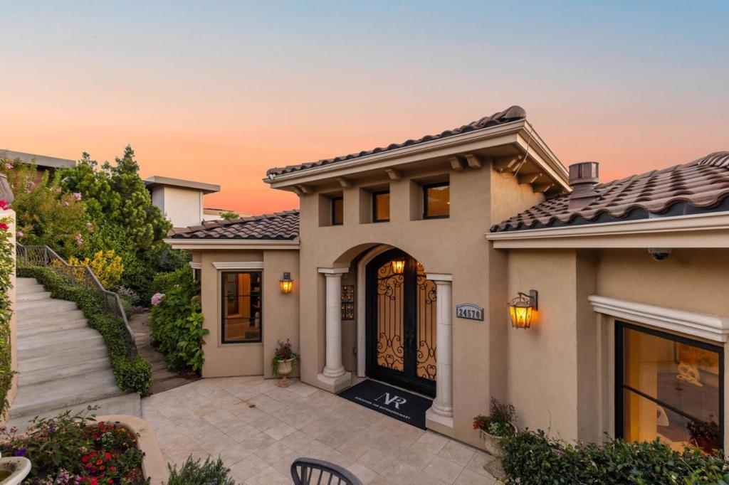 Custom-built Mediterranean-inspired estate (2011) offering panoramic Monte Bello views from each level. Nestled on a quiet cul-de-sac, this 5,693 sq ft residence combines timeless charm with modern luxury. Features include a chefs kitchen with Thermador appliances and RO filtration, a home theatre/game room with acoustic wall panels, and indoor/outdoor surround sound throughout. The home starts with serene entry with colorful garden beds, greenery and water fountain. An open family room and kitchen that opens to expansive decks with sweeping vistas. Thoughtfully designed for wellness and multi-generational living, the main floor hosts three en-suite bedrooms, while the lower level includes two additional bedrooms, a family/media room with its own large patio, and dedicated wine-closet space awaiting your personal touch. Eco-friendly amenities abound including owned solar panels, dual EV chargers, soft-water and carbon filtration systems, whole-home HRV for fresh air, and interior fire sprinklers. Incredible Views and only minutes from downtown Los Altos, premier schools, and I-280 access.