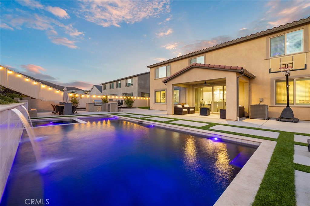 Built in 2022, this pool home blends modern design with timeless elegance, offering 5 bedrooms, 3 baths, and almost 3,400 sqft of living space, crafted for today’s luxury lifestyle. This showstopper is located in the highly sought after community of Audie Murphy Ranch in Menifee, on a cul-de-sac with owned solar and a 3-car tandem garage. The properties curb appeal boasts custom concrete stairs, artificial turf, a wide driveway and quaint porch looking to the morning sunrise. As you step inside you are greeted by 30-foot ceilings, a formal foyer, a clean color pallet throughout offering blonde LVP floors, crisp white paint and black finishes. The desirable floorplan features a MAIN FLOOR bedroom with plush carpet and a walk-in closet which is just off the guest bath boasting a single vanity and black framed walk-in shower. The whimsical great room offers tons of natural light and plantation shutters, which are throughout the property. Step through the large dining area you’ll find a custom black chandelier and 12-foot double glass doors. The chef’s kitchen is appointed with quartz counters, herringbone tile backsplash, stainless steel appliances, an extended island, white cabinets offering tons of storage and a custom dry bar across from the large walk-in pantry. The garage offers epoxy floors, and an EV charging station. Also on the main floor is a large flex space perfect for an office, library or 6th bedroom. The grand staircase takes you to the second floor boasting a large loft, built-in cabinets, and oversized laundry room with tons of storage. The three secondary bedrooms are all spacious with custom paint, plush carpet and one featuring a walk-in closet. They share a secondary bath boasting tile floors, dual vanity and tub shower combo. The primary suite offers plenty of space and an attached bath boasting two vanities and a spa super shower with two shower heads, a marble like ceramic tiled shower with honeycomb tiled floors, and a large walk-in closet. The private oasis is appointed with a large CA room, modern stamped concrete with artificial turf surrounding the salt water, pebble tech pool featuring white tile coping and a dual waterfall. The inset spa overlooks the custom-built fireplace, lounge sitting area, built-in BBQ with an eat-up bar and the large side yard perfect for soccer! Community amenities include trails, club house, skate & sport parks, pools & award-winning schools, and is between the 15 and 215 FRWYS.