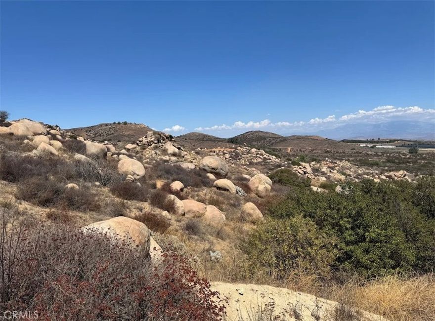 Unique opportunity to own nearly 20 acres in Perris, CA. This unimproved land features a well, approximately 3 acres of flat terrain, and a half-mile dirt driveway. With stunning 360° views, it's perfect for building a custom home, ranch, or exploring uses like agriculture, mobile homes, kennels, or small-scale ventures. Boulders on-site could be sold for landscaping. 



The property offers privacy and rural charm just minutes from Riverside. Currently, there is minimal fencing, and access is easier from the front; the back is obstructed by rocky terrain, making car access difficult. A partially constructed path exists but remains incomplete. 



Buyer to verify zoning and utilities.
