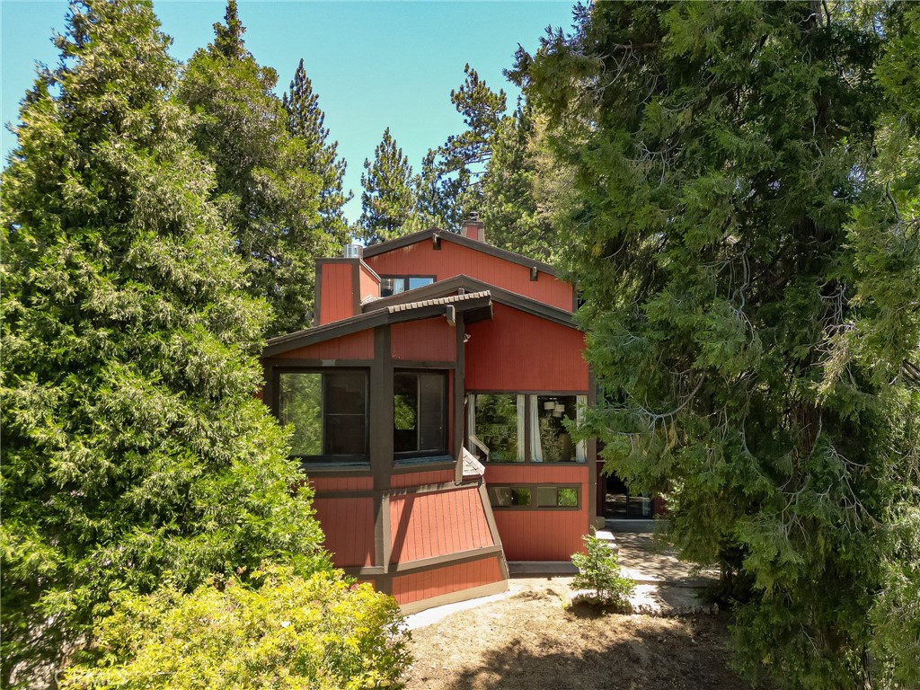 Welcome to Mile High Park, where this one-of-a-kind 3,900 sq ft lodge feels like something out of mountain daydreams. With its dramatic vaulted ceilings, exposed beams, and a floor-to-ceiling rock fireplace that crackles with cozy charm, the great room is made for fireside evenings and large gatherings. A few steps up, a kitchen with new appliances peers over the living space like a treehouse lookout—complete with a generous island, breakfast bar, and custom cabinetry.
Just off the living room, a tucked-away sunroom begs to be transformed into a creative studio or office. Other highlights include an attached extra-large two level garage and workshop, and the upper level unveils a true sanctuary: a romantic primary suite with its own fireplace and a spa-inspired bath with a shower built for 2 (or more!).
Downstairs-- a full entertainment wing with its own bar, private deck, indoor spa with a recently updated heater and a theatre room made for movie marathons or midnight concerts.
And for the practical-- New furnace for central heating, inside laundry, a fenced yard, and a huge attached garage and workshop for your mountain projects. Located on a well-maintained road just minutes from Goodwin's and Lake Gregory—with its meandering trails, peaceful fishing spots, and paddleboard-ready waters—this enchanting lodge is a rare offering in a beloved neighborhood where homes seldom become available. Newer septic tank!