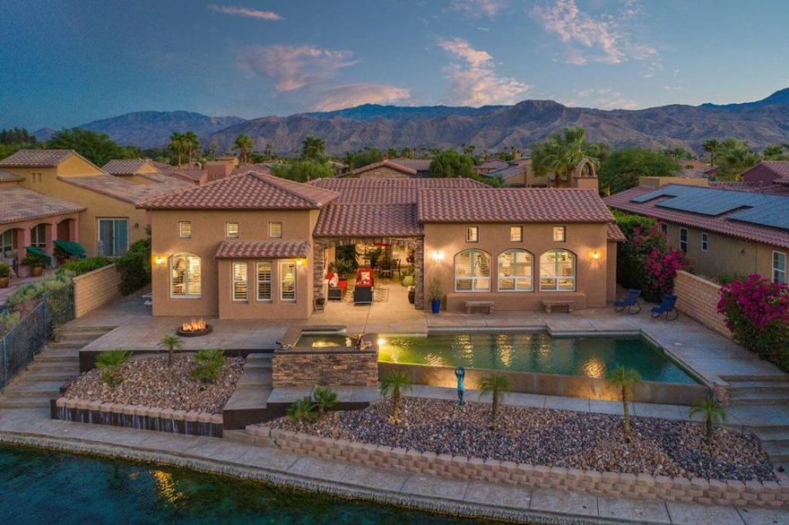 Enjoy desert living at its finest in the unique gated 9-acre lake community of Santo Tomas. This stunning waterfront home embodies all the elements you could possibly desire in a desert retreat! This rarely offered model perfect home has 4 bedrooms, 4.5 bathrooms, including an attached guest casita, and many designer upgrades. The curb appeal will immediately impress you, including a gated courtyard then enter the homes foyer that opens to the great room and looks out to the heart of the home; a large central covered patio for you to relax, entertain or even enjoy alfresco dining. The stylish oversized island kitchen features granite counter tops, professional stainless appliances and flows into the dining area & family room creating the perfect space for entertaining and casual living. The master suite offers access to the covered patio and overlooks the lake. The yard is sure to impress with an infinity pebble-tec pool & raised spa, cascading waterfall, conversation fire pit all with striking lake front views. This is the home you have been dreaming about!