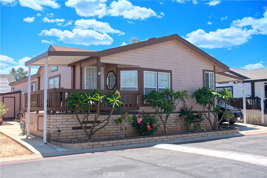 Located in the beautiful Friendly Village, right at the border of Yorba Linda, this charming 3 bedroom, 2 bath mobile home offers comfort, space, and style. Step inside to discover an inviting open floor plan featuring a spacious living room and a dedicated dining area perfect for entertaining. The kitchen boasts ample cabinet storage and modern appliances, making meal prep a breeze. The oversized primary suite is a true retreat, complete with dual closets and a bathroom featuring a luxurious soaking tub and separate shower. Two additional bedrooms offer versatility for guests, or a home office. Enjoy outdoor living on your private covered porch, or take the party to the unique backyard space designed for entertaining, offering a great setting for BBQs, gatherings, or peaceful evenings under the stars. The covered carport with extended driveway is ideal for multiple vehicles. Lush landscaping with mature plants and flowers adds charm and serenity. Situated near shopping, dining, and just minutes from the 91 and 55 freeways, this is your opportunity to enjoy affordable homeownership in a quiet, resort-style community.