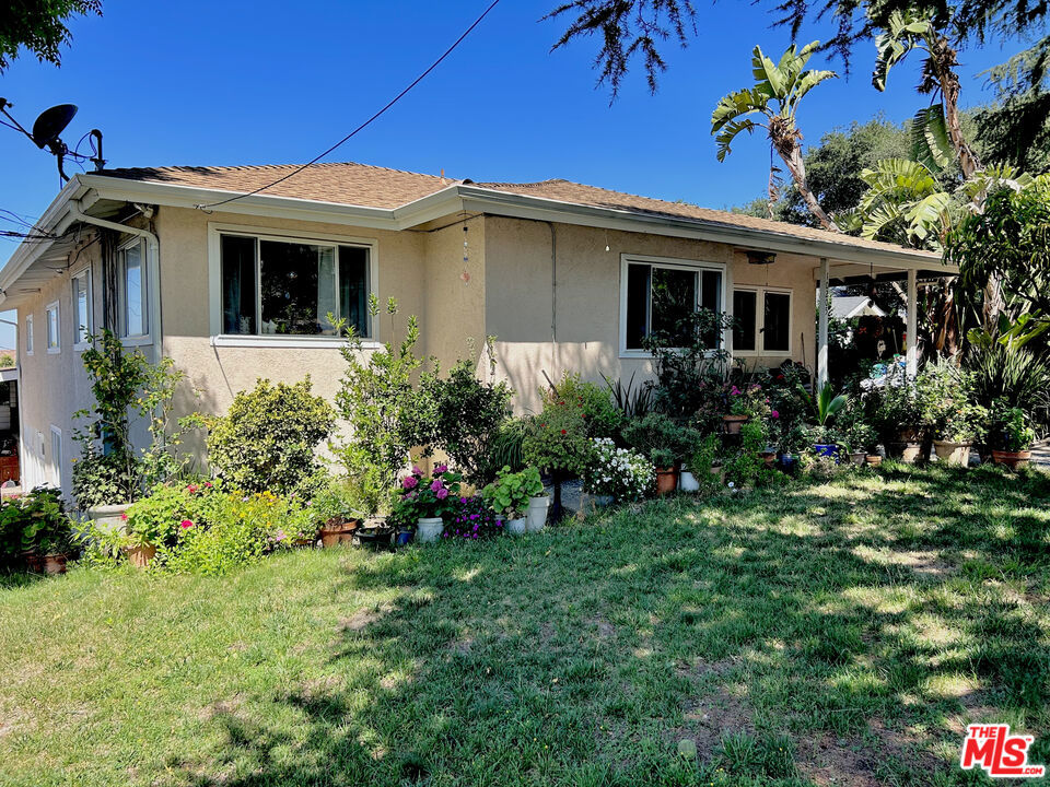 Tucked away in the peaceful hills of Tujunga, this beautifully updated 3-bedroom, 2-bathroom home: a rare opportunity to own a private slice of Southern California paradise. From the moment you arrive, you're greeted by a sense of calm and seclusion, enhanced by the quiet location, mature landscaping, and mountain views that frame the property like a painting. Whether you're a growing family, a remote-working professional, or a couple seeking a place to both entertain and recharge, this home offers a balance of warmth, functionality, and lifestyle. You will immediately feel at home in the inviting living room, where a classic fireplace and original floors blend seamlessly with the rest of the home. Natural light pours in through oversized windows, creating a cozy-yet-open atmosphere that flows effortlessly into the heart of the home. The kitchen is perfect for catering to groups of all sizes, and has ample storage, perfect for everyday cooking or hosting memorable gatherings. All three bedrooms are thoughtfully positioned to provide privacy and comfort. The primary suite is a true sanctuary, featuring vaulted ceilings, a spacious en-suite bathroom with direct access to the stunning backyard retreat. Imagine stepping out of your bedroom each morning for a peaceful swim or soaking in the spa under the stars at night. This is California living at its best. Downstairs, a versatile basement area provides over 400 square feet of flexible space, ideal for a home office, guest suite, gym, media room, or creative studio. There's also a third full bathroom and laundry area, making this lower level a completely functional extension of the main living space.But the crown jewel of this property is the resort-style backyard. Designed for both relaxation and celebration, it features a sparkling heated pool and spa with waterfall, multiple seating and lounge areas, and beautiful hardscaping that invites alfresco dining and outdoor fun year-round. Whether you're hosting weekend BBQs, pool parties, or simply enjoying a quiet sunset with a glass of wine, this space delivers the lifestyle most people only dream about. Additional features include a two-car garage with high ceilings (can be converted to a large ADU), gated driveway parking, updated central HVAC, and a fully fenced yard offering privacy and security.