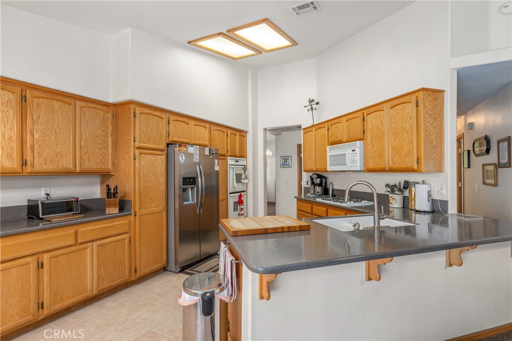 Discover your dream home in this single-story home, ideally located near schools, shopping, and city services. Nestled at the end of a peaceful cul-de-sac, it offers exceptional privacy and a beautifully landscaped yard with RV parking. The oversized 3-car garage provides abundant space, while vaulted ceilings and a cozy fireplace create a spacious, inviting interior. Enjoy outdoor dining under the covered patio and cook in a stylish kitchen with custom countertops and elegant tile flooring. Filled with thoughtful upgrades, this home blends comfort, convenience, and charm—your perfect retreat awaits!
