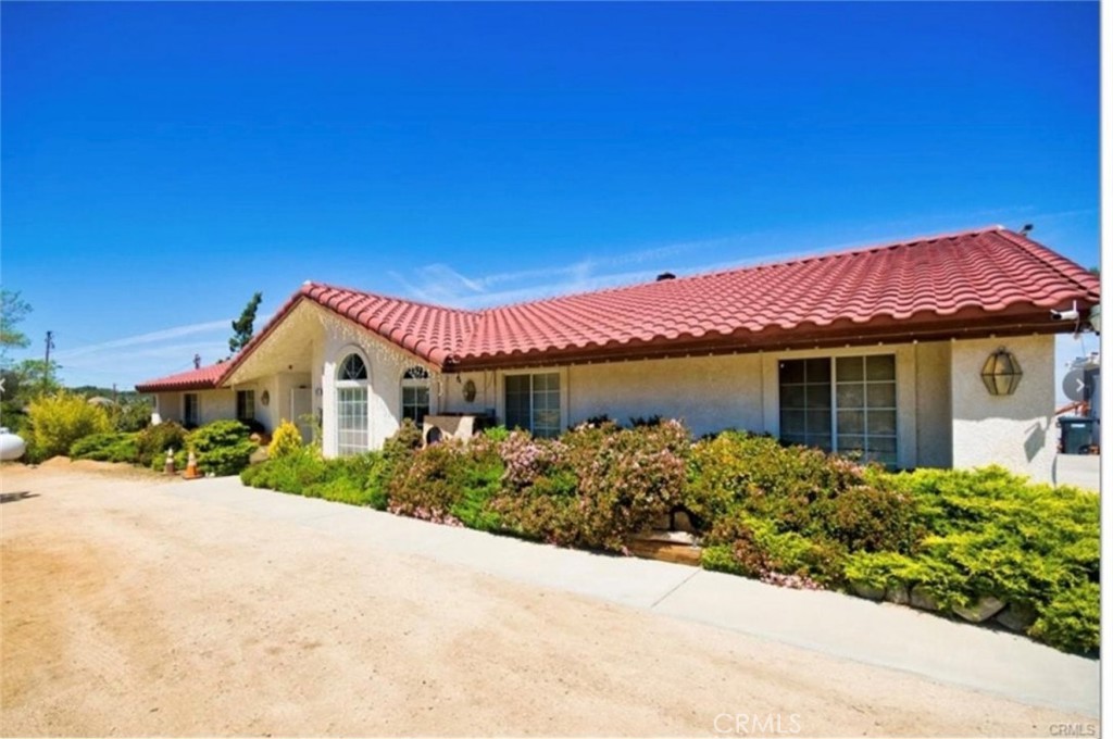 Welcome to this charming 3-bedroom, 3-bathroom home offering 1,750 sq. ft. of comfortable living space on an expansive 101,495 sq. ft. lot. Whether you're looking for a peaceful retreat or a property with investment potential, this home delivers. Inside, an inviting living room with abundant natural light creates a warm and welcoming atmosphere. The chef's kitchen is designed for function and style, featuring a spacious layout perfect for preparing meals and entertaining. The primary bedroom is a private sanctuary, offering ample space and comfort, while the two additional bedrooms provide flexibility for family, guests, or a home office. Two updated bathrooms add to the home's modern convenience. Enjoy seamless indoor-outdoor living with a patio door leading to a private, larger patio and BBQ area, perfect for entertaining under the desert sky. Experience the benefits of single-family living with the convenience of a gated garage offering two tandem parking spots and a guest parking space, plus an elevator for easy access. Additional features include a walk-in refrigerator for added storage and Japanese Apricot Trees that present an opportunity for an extra income stream. Located near the 138 Access Road, schools, and dining, this home blends tranquility with everyday convenience. Don't miss out on this rare opportunity to own a sprawling property with endless potential in the heart of Pinon Hills!