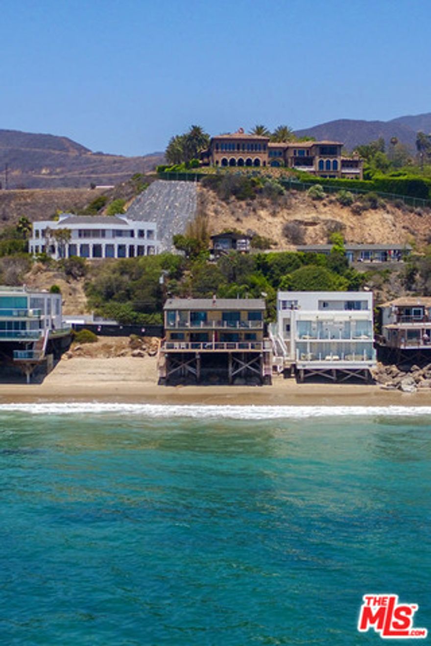 Triplex situated on 50 feet of prime Malibu Road Beachfront. An amazing penthouse spanning the whole upper level sits this decorators own 3 bedroom 2 bath showplace. The oceanfront great room includes gourmet kitchen, living room with fireplace and an incredible dinning area all leading to expansive out door decking to entertain and watch the whales and dolphins.  The lower level includes two units that are both 2 bedrooms one with one bath one with 1.5 baths. They make for great rentals or guest suites. The property also has a 4 car garage and ample parking in front of garages or street parking. It is currently zoned as a 4 unit but is now 3 units. Great owner user while having rental income or perhaps turn the 4,032 SQ Ft(Per assessor) into a single family residence (subject to City of Malibu Approval) City of Malibu Septic Operating Permit on File.