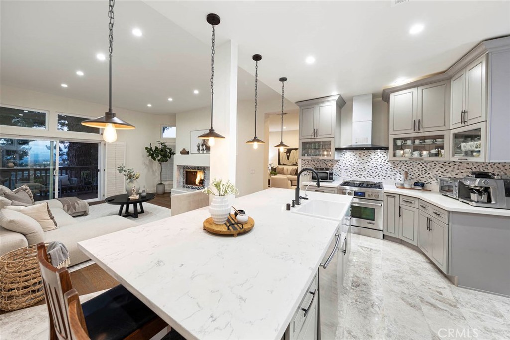 Experience resort-style luxury in this beautifully renovated home, perfectly situated within the prestigious guard-gated community in Newport Beach. Designed with a seamless blend of sophistication and comfort, the residence showcases quality craftsmanship, and thoughtful upgrades throughout.
A luminous entry welcomes you to an open floor plan with soaring ceilings and a skylight. The main level features a guest bedroom with full bath, formal living and dining rooms—both with elegant marble fireplaces—a spacious family room, and a versatile loft. French doors open to a view deck, ideal for indoor-outdoor entertaining. The gourmet kitchen is a chef’s dream with custom cabinetry, a quartz-topped island, breakfast bar, and premium stainless-steel appliances.
Upstairs, the primary suite offers vaulted ceilings, panoramic city-light and treetop views, a cozy sitting area with fireplace, a spa-inspired marble bath with freestanding tub, and a generous walk-in closet. Additional highlights include new wood and marble flooring, custom built-ins, quartz counters in all bathrooms, central air conditioning, and a three-car garage with epoxy flooring and long driveway for added parking.
Residents of Harbor Ridge enjoy four pools and spas, three tennis courts, 24-hour gate-guard security with patrol. The community is just minutes from world-class shopping and dining, top-rated schools, Pelican Hill Resort and Golf Course, and the most beautiful beaches in Orange County. This extraordinary home embodies the very best of coastal living in Newport Beach.