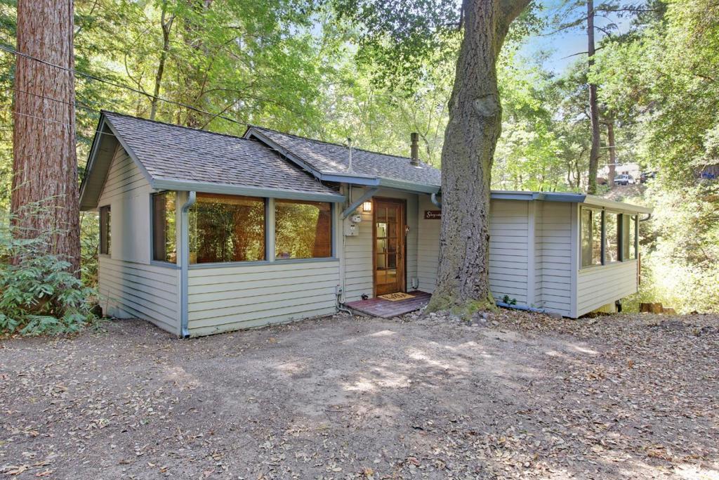 This charming cottage sits on the bank of the San Lorenzo River, just far enough off Hwy 9 to enjoy the privacy that Boulder Creek has to offer. If you're looking for a quiet and absolutely peaceful setting to call home, you've found it! Updates to the kitchen, roof, heating, and septic have been made while maintaining the original character. This two-bedroom and one-bath home is just a short stroll to the Sawmill restaurant and Garrahan Park. The spacious deck overlooking the river is the perfect place to enjoy your morning coffee or dine with friends on a warm summer night. A fantastic location with easy highway access, 173 Sequoia has more convenience than most mountain homes could ask for. A large, usable lot includes two parcels with ample space for future development (buyer to verify feasibility) and plenty of increased value. Additional features include a large carport, a detached shed, and a basement area with laundry and storage. Seller will consider carry-back financing.