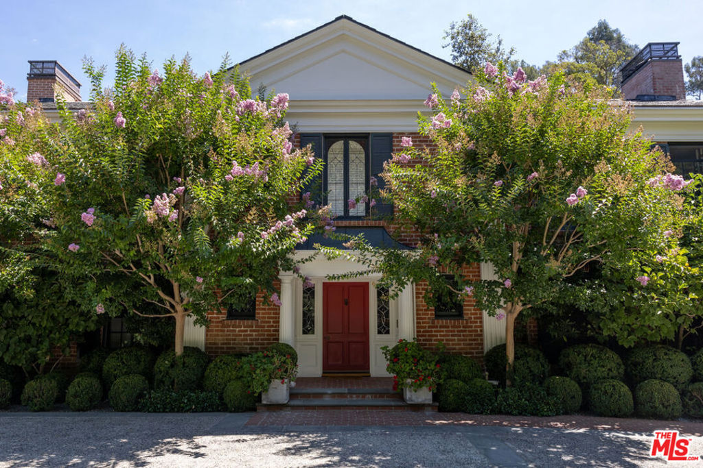 Tucked away in a coveted Bel Air enclave, this stunning Georgian estate is the epitome of timeless sophistication and serene privacy. Set on over an acre of beautifully manicured grounds, this double-gated, hedged property welcomes you with a grand circular driveway and motor court, creating a stately approach to the residence. Step inside to a breathtaking foyer with a sweeping staircase, setting the tone for the home's classic elegance. Formal living spaces include a well-appointed living room, a handsome wood-paneled office, and an elegant formal dining room. The expansive chef's kitchen opens to a welcoming family room with high ceilings, ideal for intimate gatherings. Just off the kitchen, a nanny's suite with an en-suite bath, a full laundry, and a service area complete the main level. Upstairs, the private quarters boast a luxurious primary suite with two spacious walk-in closets and a spa-inspired bathroom. Three additional bedrooms, two well-appointed bathrooms, and a cozy library provide for thoughtful relaxation. Outdoors, the estate's grounds are a true sanctuary. Rolling lawns, winding paths, and lush gardens create a tranquil ambiance, while a sparkling pool and spa with a generous pool deck provide the perfect backdrop for relaxation. A covered dining terrace, complete with an outdoor kitchen and pool bath, is ideal for alfresco entertaining. A charming guest house with one bedroom, a full bathroom, a living room, and a kitchen completes this exceptional property, offering guests their own private retreat. This remarkable home exudes refined luxury in an idyllic Bel Air setting, where elegance and privacy harmoniously converge.