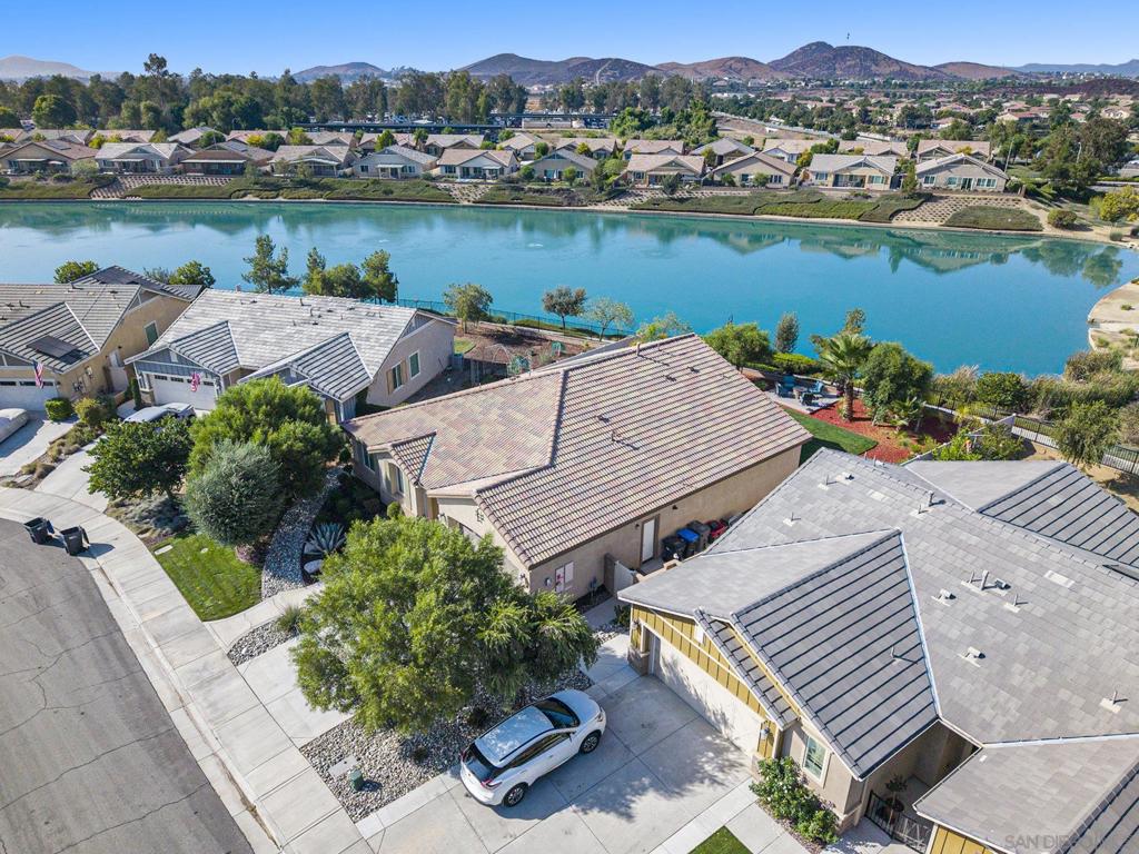 Impeccably maintained and upgraded home on a premium water front site in the heart of gated Menifee Lakes. Extensively upgraded inside and out, the smart single level layout has everything you need in just the right places and features high end custom work including crown moulding, window casements, engineered maple wood flooring, paneled wainscoting, professional gallery lighting, and much more. The expansive kitchen has abundant storage, a large stone island, pristine cabinetry, and stainless appliances including a built in gas range, double wall oven. The space opens up perfectly to the living area which is flooded with natural light and flows out onto the back patio. Sit and sip coffee on the porch while overlooking the serene lake setting or stargaze by night from the custom deck with flagstone fire pit. The home has been meticulously maintained and loved by the original owner and is truly in turn key condition. Additional noteworthy features include an oversized two car garage with extra deep bay for work/storage, EV charger, tankless water heater, security system, smart thermostats, and the list goes on. Residents in Menifee Lakes enjoy easy freeway and shopping access, an incredible host of community amenities - including two lakeside pools, luxury cabanas, splash pad, waterslides, parks, club and fitness rooms, walking trails, and more. Combine this with the peace of mind that comes with gated access and this remarkable lake front opportunity is just too good to pass up.