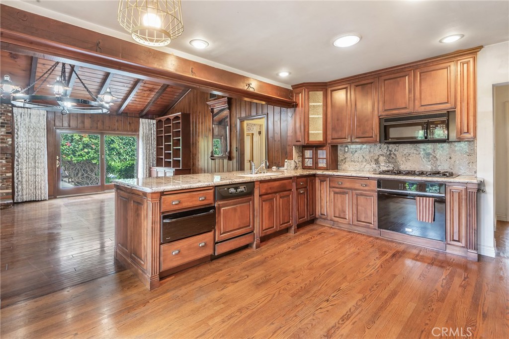Step into timeless charm and comfort in this 3-bedroom, 2-bathroom home situated on an almost 6000 sq foot in one of the most desirable locations in Gardena. From the moment you arrive, you’ll appreciate the curb appeal created by mature landscaping, a concrete tile roof, and a fully gated yard offering both privacy and presence. Inside, rich hardwood floors flow throughout, complemented by vaulted ceilings with exposed beams, crown molding, and elegant rounded ceilings. The formal living room features one of two fireplaces, a custom made chandelier, dual-pane Milgard windows and solid wood Anderson sliding doors. The updated kitchen features granite countertops, custom wood cabinetry, a pantry, double sink, instant hot water, a dishwasher, and a Thermador warming drawer. Recessed lighting and custom drapes elevate the space with warmth and style. The detached garage offers generous space for a workshop and includes a 220V sub-panel, ideal for hobbyists or future expansion. With tons of storage, two fireplaces, and thoughtful upgrades throughout, this home delivers comfort, functionality, and timeless design. A street to alley lot offers access from the front and rear of the home. There is plenty of room for an RV or potential ADU.