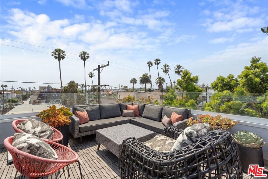 Situated just steps away from the historic Venice Canals, this architectural home features soaring ceilings, walls of glass, and a truly special primary suite. Fully gated for ultimate privacy, this residence is highlighted by a flexible floor plan that can be configured to suite your lifestyle. The front patio seamlessly connects through large sliding glass doors into the sun drenched living and dining rooms that feature vaulted ceilings. Stylish hardwood floors lead you past the two guest rooms and a Jack and Jill bathroom to the West facing kitchen and family room. Flooded with natural light, the spectacular kitchen is punctuated by Italian marble countertops, custom cabinetry, and high end appliances. Perfectly suited for entertaining, the kitchen blends with the family room for that "great room" space while voluminous ceilings and custom built-ins a create grand feeling. Upstairs the third level is wholly reserved for the jaw dropping primary suite. Sliding glass doors take you out to a private balcony where cool ocean breezes flow past the walk in closet to the enormous, recently remodeled ensuite bathroom that features a dual vanity, separate shower and massive tub. The final level of the home is an awesome rooftop deck with views of the Canals and is the ideal setting to take in Sunsets. This home also features a flex space that could be used as gym, office, or game room. This unique home is a sanctuary in the city while also being centrally located near the beach, Abbot Kinney, and Marina Del Rey. Don't miss out on the special lifestyle this home affords!