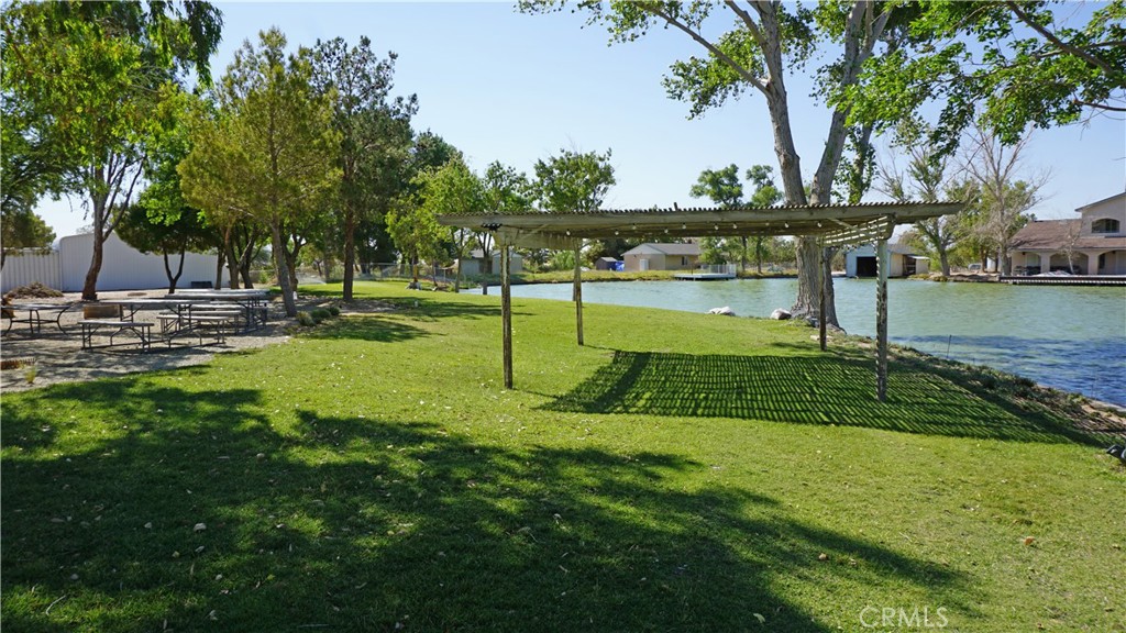 Introducing a breathtaking fenced 2.38-acre lot located on beautiful Lake Wanini. The entry rolling gate is 6 foot high wrought iron with custom brick pillars. This picturesque property is adorned with an abundance of lush trees and grass, creating a tranquil oasis. A delightful picnic area provides a perfect spot for outdoor gatherings and enjoying the scenic surroundings. Additionally, the lot offers a spacious 40x40 metal garage boasting two 20x20 roll-up doors, ideal for storage or as a workshop. Adjacent to the garage, there is a convenient 30x40 metal covered parking area with a concrete pad, offering ample space for vehicles or recreational equipment ( Shop measurements are approximate ) . Sitting in the garage is a 2020 Forest River tow behind camping trailer. The length of the trailer is 36.33 ft , its 8ft wide and 11.25 feet tall. Its fits perfect. This trailer can be included in the sale with the right offer. Water is readily available on the property, and electricity is located nearby. Embrace the beauty of nature and envision the possibilities on this remarkable lakeside property. Lake Wanini offers Waterski and wake boarding on a 1 mile oval track around a sand and treed island.