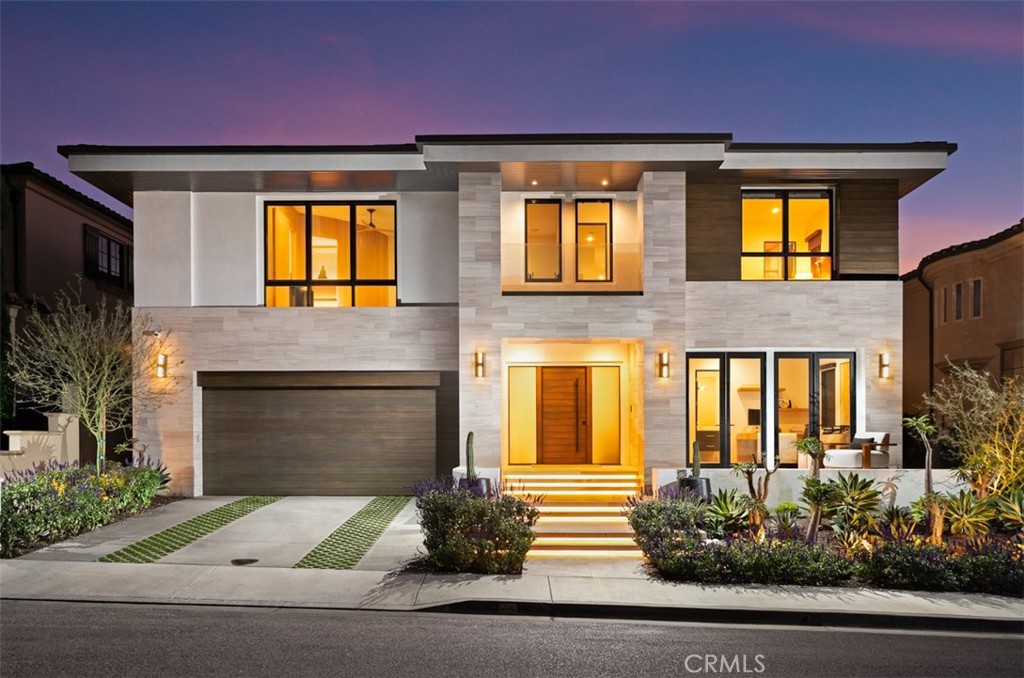With captivating soft-contemporary architecture, striking interior design and panoramic ocean, Catalina
Island and coastline views, this magnificently modern custom home is without compare. Located just steps
from the sand in Dana Point’s exclusive guard-gated Ritz Cove collection, the luxurious residence takes full
advantage of its beach-close setting by offering seamless indoor/outdoor living that blends walls of
automated glass pocket doors with an open-concept floorplan. Natural stone and wood details embellish an
exterior that stands apart from adjacent homes while complementing the neighborhood’s prestigious
aesthetic. Approximately 6,250 square feet, the generous two-level design reveals a formal entry with views
through to the backyard, a custom elevator to the rooftop deck, and an atrium-style double-height foyer with
a dramatic staircase and seamless access to a fireplace-warmed lounge and seating area with side-yard
fountain. Disappearing walls of glass open the rear of the home to the backyard and welcome light into a
family room with fireplace, large dining room, a stunning wine wall with backlit onyx, and an open chef’s
kitchen that rivals those found in glossy architectural magazines. An island with dual-waterfall edges is
joined by custom wood cabinetry in two distinct finishes, polished stone countertops, and top-tier stainless
steel appliances including a six-burner Wolf range with griddle and two ovens. Convenience is enhanced by
a hidden prep kitchen with cooktop, second refrigerator and abundant storage. Four ensuite bedrooms with
walk-in closets and five and one-half baths ensure comfort and privacy for residents and guests, while a
main-level office opens to a sunny front patio and could become a fifth bedroom. Everyone will enjoy a
second-floor gym and massage room, each featuring a soothing interior waterfall. For movie night, the gym
easily becomes a home theater, complete with a state-of-the-art Denon AV receiver and surround sound.
Escape to an ocean-view paradise in the primary suite, which showcases a covered full-width balcony,
sitting area with fireplace, and custom closets. Gold fixtures shine in the primary bath, harmonizing with a
freestanding tub, two floating vanities, and an oversized shower with custom built-in body-conforming
lounger. Solar power, whole-house Sonos audio, and a three-car garage with two EV outlets
are included, and the backyard boasts a resort-style pool, spa, and built-in BBQ.