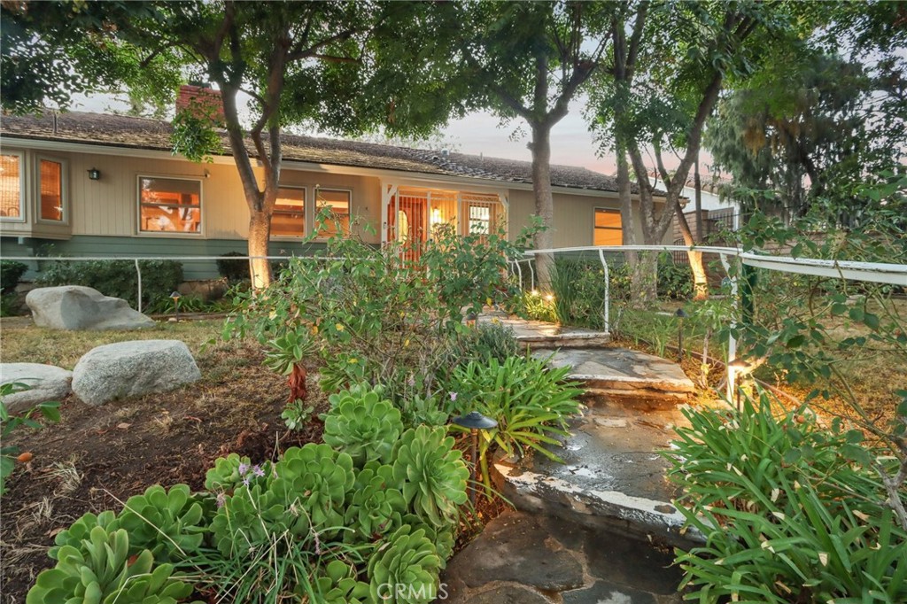 Charming Ranch-Style Retreat in the Heart of Old Granada Hills. Nestled in a picturesque Granada Hills neighborhood, this beautifully maintained single-story ranch home offers timeless character, thoughtful updates, and incredible potential. Situated on an expansive 14,997 sq ft lot, this 4-bedroom, 4-bath home spans 2,271 sq ft of inviting living space—perfect for entertaining, relaxing, or expanding your vision. Step inside to discover a light-filled kitchen adorned with granite countertops, travertine backsplash, stainless steel appliances, a built-in refrigerator, and a charming bay window. The spacious eat-in area flows effortlessly into a formal dining room, ideal for hosting family and friends. The warm and inviting living room is the heart of the home, featuring stunning wood-beamed ceilings, a classic marble fireplace, and elegant French doors that open to your private backyard escape. With four generously sized bedrooms, including two en suites, there’s room for everyone to unwind. The primary suite is a true sanctuary with a walk-in closet, French doors to the backyard, and a luxurious bath complete with a soaking tub and separate shower. A dedicated indoor laundry room adds modern convenience, while original details and tasteful upgrades preserve the home’s unique charm. Outside, the possibilities are endless. Entertain year-round under the expansive 660 sq ft L-shaped covered patio, enjoy cozy evenings around the gas firepit, or soak in the rock spa under the stars. The huge backyard is a blank canvas—whether you envision lush gardens, a pool, or a playground, there’s space for it all. Looking for more flexibility? The detached two-car garage, complete with an additional storage room or den, offers fantastic ADU or guesthouse potential. Located in the highly sought-after Granada Hills Charter High School district and just moments from the beloved Granada Hills Farmers Market, shops, and dining, this home combines comfort, character, and convenience in one incredible package. Don’t miss the opportunity to create your dream lifestyle in this one-of-a-kind Granada Hills gem!