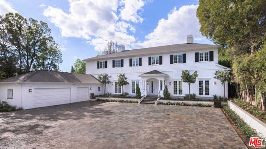 Set behind gates and complete with a large motor court that can accommodate 12+cars, this newly-completed traditional home is the epitome of elegance. The foyer with chevron floors opens up to the formal dining room and the grand formal living room with fireplace and built-ins. Floor-to-ceiling French doors spanning the length of the home allow for natural light to pour into every room. The chef's kitchen features Viking appliances, walk-in pantry, and center island with breakfast bar. The family room boasts plenty of room to lounge by the fire or entertain at the bar. An oversized bay window exemplifies how the property perfectly blends contemporary with classic charm. The office/library with wet bar and a guest room are also located on the main level. Upstairs, find the master suite with dual closets and peek-a-boo views of the Getty Museum, as well as four additional en-suite bedrooms. Infinity pool, grassy yard, vegetable garden, and three-car garage complete this beauteous estate.
