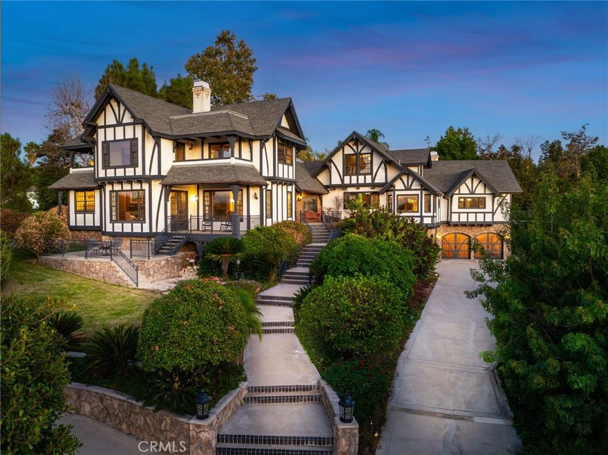 A one of a kind gated Tudor estate in the prestigious Hawarden Hills set amid tranquil grounds offering the perfect blend of sophistication, privacy and historic allure with contemporary potential. Your vision will complete the story. Crafted by renowned builder Tom LaCava as his personal residence, every inch of this home showcases remarkable craftsmanship and detail — from hand-selected fine oak banisters and custom-built cabinetry to dramatic wood and gas fireplaces and artful alcoves designed for displaying sculptures and fine art. Perched on a scenic hilltop, the residence is thoughtfully oriented to capture sweeping 180° views of city lights, mountains, and sunsets through large picture windows in nearly every room. A grand two-story foyer introduces the home’s elegant interiors, leading to a formal living and dining room with high ceilings, gorgeous oak hardwood floors, and private balconies. The chef’s kitchen features a breakfast nook, butler’s pantry, walk-in pantry, granite countertops, and a balcony ideal for al fresco dining. Designed for entertaining, the home offers a billiard room with bar and a family room with loft, both highlighted by vaulted beamed ceilings, fireplaces, and French doors. The estate is surrounded by walking paths, a sparkling pool and spa, cabana, and sun deck. Let every generation find its corner, there are 2 ADU's on the property, one is 2 Bed / 2 Baths 1,178 Sq Ft with its own 2-car garage and offers beautiful city light views. The other is a small studio suite pool house. A true legacy home with a timeless address.