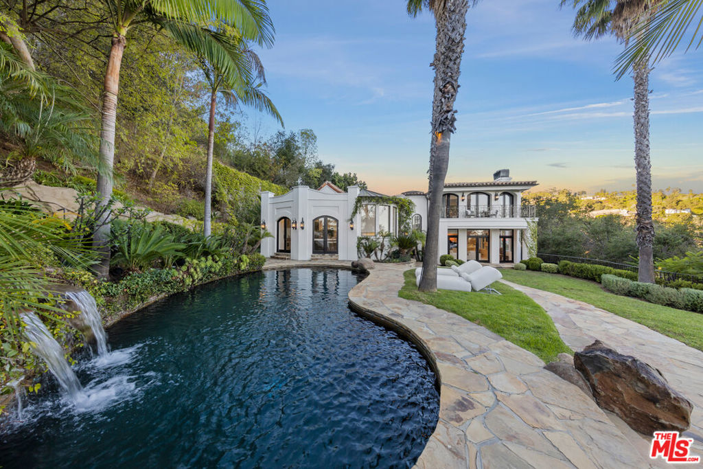 Escape to a magnificent private oasis in the heart of Beverly Hills with birds eye views from the city to the ocean. Enter through gates up a 500 ft long private driveway under lush foliage to a spectacular villa set on over an acre. A blend between European sophistication and modern design, this palatial villa embodies California living at its finest. The beautifully appointed main house has an open floor plan with seamless indoor-outdoor flow to the sprawling grounds and pool area. The main level features a chef's kitchen, living room, dining room, great room, office, and 3 guest suites. The entire upstairs consists of the extraordinary primary suite, replete with jetliner city and ocean views, a fireplace, dual oversized closets and balconies. The perfectly appointed primary bath has a massive rain shower, separate tub and dual vanities. The guest house consists of two separate suites situated nicely above the garage. Additional amenities include a newly built gym as well as a state of the art cinema room. Surrounded by lush landscaping, the expansive grounds showcase a pool with waterfall, al-fresco dining areas, sky bar, fire pit and more, all with panoramic views. There is also significant land that has not yet been built on, with endless possibilities. Smart-home and security features throughout. Moments from the best dining, shopping and entertainment the city has to offer.