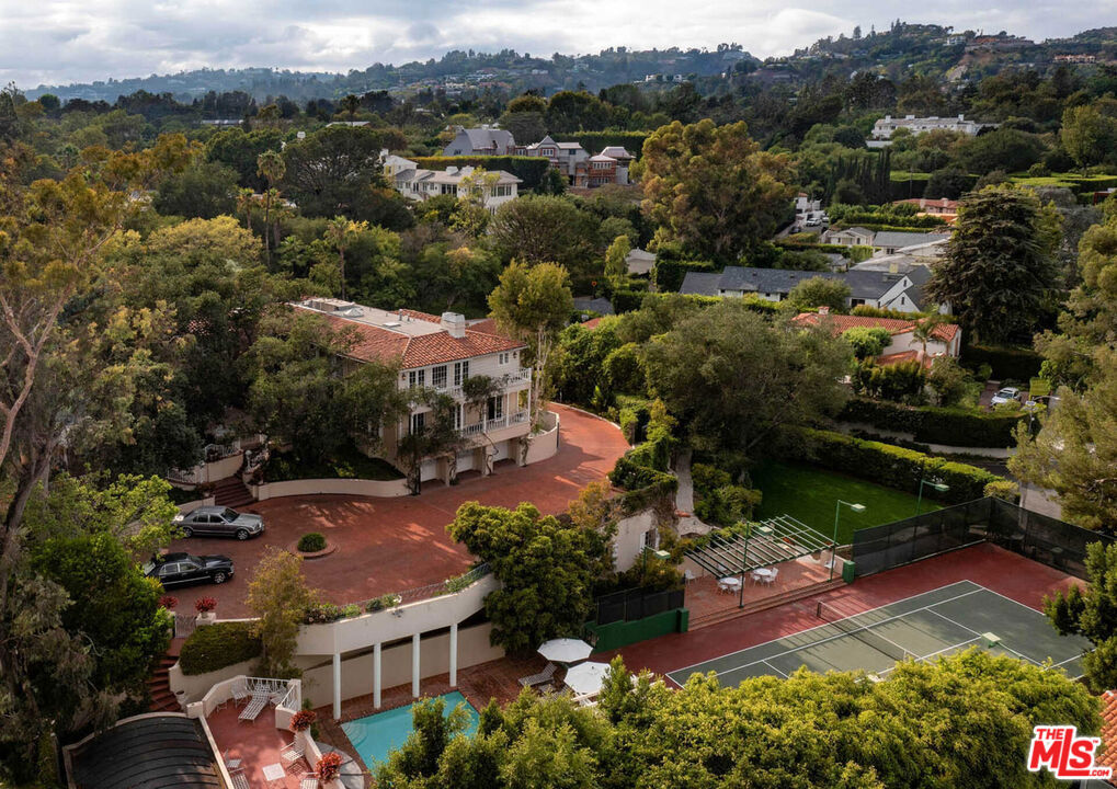 Architectural pedigree meets Old Hollywood. Once in a generation & rare opportunity to own an iconic estate steeped in entertainment history. The Fries Estate, once owned by Paramount Pictures, is an incredible promontory compound on appx. 1.2 acres w/ a legendary pool house designed by Paul Williams. Features: long gated driveway w/ massive motor court, main home has ideal floor plan w/ grand scaled public rms, primary w/ sitting rm, dual walk-ins, frplc + 2 en-suite bdrms up. 2 staff on main level. Lower level w/ huge theater, game rm, wine cellar, gym, staff rm & 2nd kitch. Your own personal Beverly Hills Hotel experience awaits. Enjoy days at the pool & pool house, create your own private Polo Lounge in the brick courtyard w/ fountain & enjoy walks in the park-like grounds & tennis in the N/S court w/ pavilion. Verdant landscape & mature trees envelope the home in privacy & create a magical backdrop for living/entertaining in style. The essence of quintessential Beverly Hills.