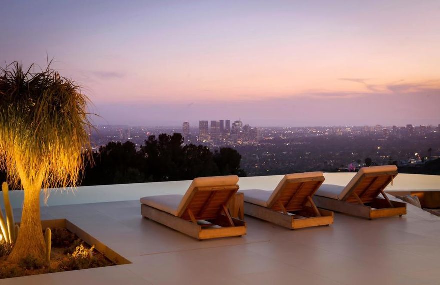 Step into the spotlight in this brand-new 13,500 SF contemporary masterpiece, perched in the legendary Bird Streets high above the Sunset Strip. Designed by the iconic Vantage Design Group, this architectural marvel of concrete and steel is a showpiece of style, sophistication, and luxury. Offering breathtaking panoramic views, this estate is a seamless blend of cutting-edge design, opulent indoor-outdoor living, and top-tier amenities, including two elevators (one is commercial-grade). Experience the grandeur of this home, starting with a cantilevered glass living room that appears to float above the city, leading to a sleek dining area and gourmet kitchen crafted for the most discerning chefs, featuring exquisite stone countertops and top-tier appliances. The high-tech family/media room boasts a statement bar and an immersive 12'x9' LED media wall, perfect for exclusive premieres or intimate gatherings. With 5 lavish bedrooms and 8 impeccably designed bathrooms, the primary suite offers a serene sitting area, spa-like ensuite with dual vanity, and a custom walk-in closet designed for refined elegance. Seamless floor-to-ceiling motorized Shuco glass doors open to an expansive 4,000 SF deck, where you can unwind by the sunken fire pit, bask in the glamour of the 175' infinity-edge pool with spa, Baja shelf, and sunken seating area, or entertain under the stars in ultimate style. Spanning 1.2 acres, this private sanctuary features drought-tolerant landscaping, 5,000 SF of lush gardens, meandering paths, and a citrus grove, all designed for balance and well-being.