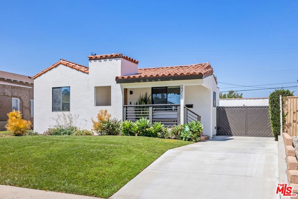 Welcome to a charming original 1920s Spanish, extensively remodeled throughout with modern finishes and set back from the street with a grassy lawn and drought-tolerant landscaping. Pass the front porch and enter through a character-rich wooden door, complete with a speakeasy window, to discover an open-concept floor plan perfect for entertaining. The bright, light-filled living room flows into the adjacent dining area which continues to the kitchen, updated with beautiful quartz countertops, center island with farm sink, stainless-steel appliances, and new hardware. The primary bedroom is spacious, and its en-suite bathroom is appointed with stylish tiling and a dual-sink vanity. Secondary bedrooms are also filled with light, one of which is currently used as an office, and stackable laundry is positioned central to the living spaces. Outside, enjoy a large backyard with grassy play space plus a trellis-covered outdoor dining room for savoring evening meals and afternoon drinks. For the creative artist, there is even a converted and detached music studio, fitted with acoustic treatments! Or, the possibilities are endless to easily reconfigure this bonus space for yoga, meditation, gaming, study, remote work, or anything imaginable. There is ample street parking as well as room for multiple cars in the long gated driveway. Welcome to this excellent location near parks, schools, houses of worship, and freeways, just moments to LA icons like the Forum, SoFi Stadium, LAX, and more.