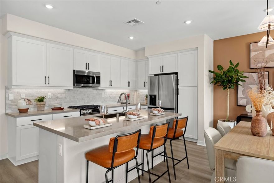 BRAND NEW MODEL home in the gated Mirasol community! This energy-efficient home features 2 bedrooms, 2.5 bathrooms, and 1,373 square feet of thoughtfully designed living space. As a desirable corner end unit, it offers abundant natural light and a fabulous open flow. Upon entry, a welcoming foyer includes a convenient storage closet and direct garage access. Upstairs, the open-concept living area features a charming balcony—perfect for enjoying fresh air and breezes. The beautifully appointed kitchen showcases designer-selected white shaker cabinets, upgraded quartz countertops with a decorative backsplash, and a full suite of LG stainless steel appliances, including range, microwave, dishwasher, and refrigerator. The third level offers two spacious bedrooms, each with its own en-suite bathroom, along with a stacked laundry closet complete with washer and dryer for added convenience. Premium upgrades and finishes throughout further enhance this modern residence. Centrally located near schools, parks, shopping, and dining, with easy access to the I-10 and I-605 freeways—providing a smooth commute to both DTLA and Orange County. Don’t miss your chance to own new in this sought-after community!