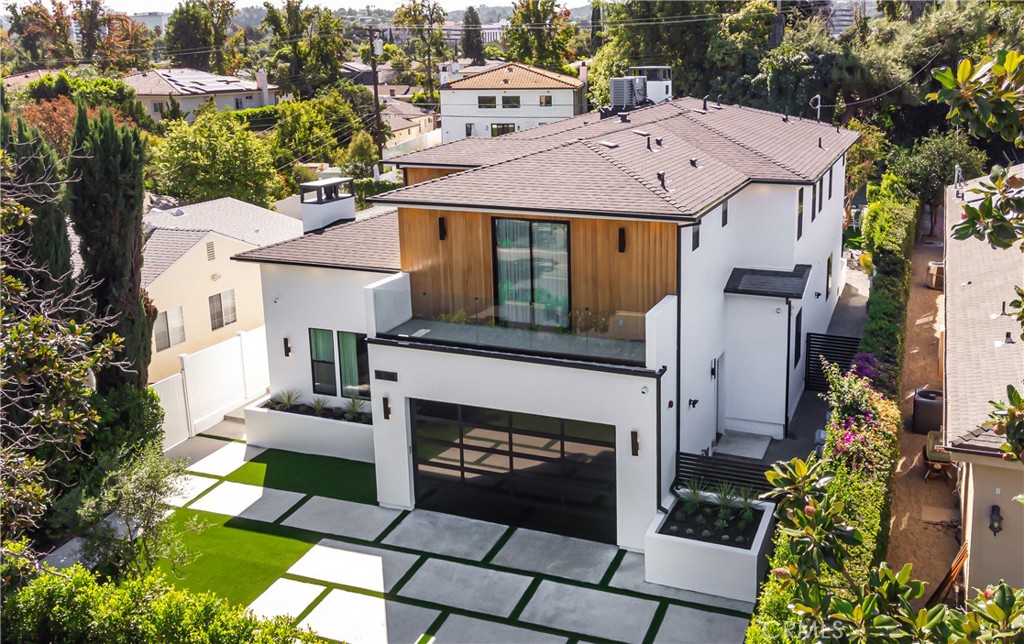 Come view this brilliantly designed contemporary home. Settled on an impressive lot, this Encino home offers warm, indoor/outdoor living. Behind the grand door, you ll experience high ceilings, white oak herringbone floors, and a spacious living room with a gorgeous fireplace. In the formal dining room, 10ft glass pocket doors open to a large covered patio for an indoor/outdoor experience. The DaVinci Collection dual fireplace serves as a partition to the opulent family room and chef s kitchen that is equipped with a double island, top-of-the-line appliances, Sapienstone countertops and full backsplash, a walk-in pantry, and more. This area is completed by 10ft pocket doors that open onto a vast entertainer’s outdoor space replete with a pool, spa, and outdoor kitchen. The LED lit staircase leads to the owner s suite which contain a lavish fireplace and 10ft pocket doors that spill onto the oversized terrace. The bespoke, spa bath is dressed with dual sinks, an impressive makeup vanity, a soaking tub, and custom glass wardrobe doors. Three additional ensuite bedrooms and a lovely laundry room grace the upstairs with luxurious finishes. Downstairs features a bonus media room with surround sound and speaker system. This smart home is a an entertainer s dream! A true oasis coupled with a rare amount of flat yard makes this estate fit for the most discerning occupant in one of the most desirable areas.