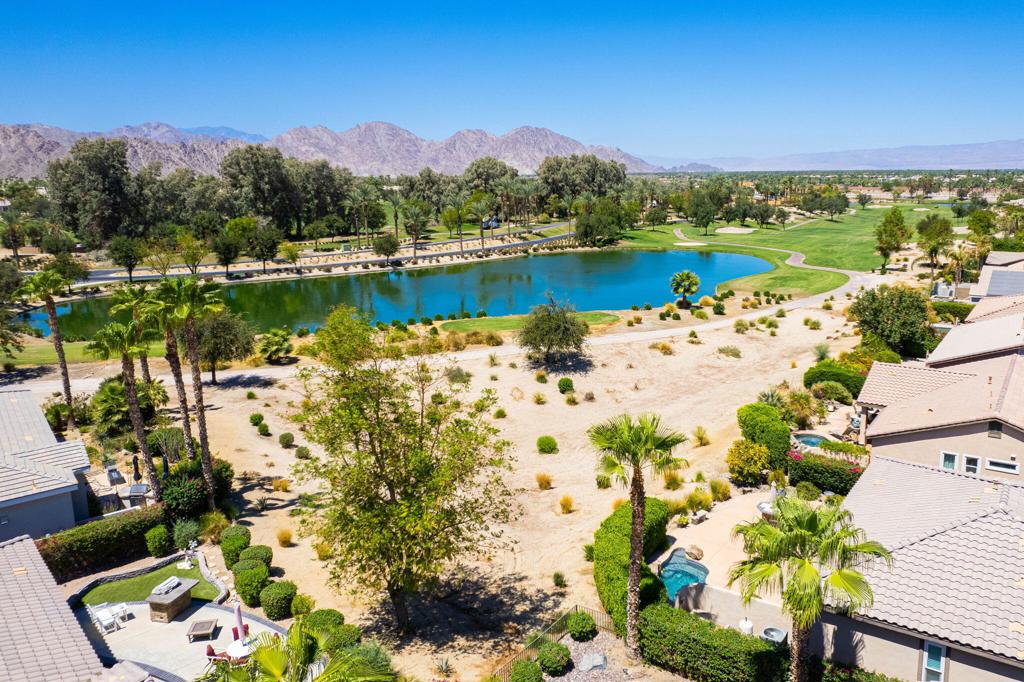 RENTED 2-1-2026 thru 4-30-2026. Welcome to your dream retreat just off the 18th Tee at Trilogy La Quinta! This stunning west-facing oasis, complete with a charming Casita, offers a resort-style backyard that's perfect for entertaining or relaxing. Picture yourself unwinding in the pebble-finished spa, enjoying the tranquil sound of the rock waterfall, or grilling up a feast at the fully equipped BBQ island. With panoramic views of the mountains, lake, and golf course, your evenings on the shaded patio will be nothing short of magical. Step inside this 1,806-square-foot single-level gem to find three spacious bedrooms, three luxurious baths, and a great room designed for comfort with a cozy tile-encased fireplace and custom built-ins. Recently updated flooring throughout the home. The primary suite is your personal sanctuary, featuring plantation shutters, private patio access, a walk-in closet, and a spa-like en suite bath. The gourmet island kitchen, open to the dining room, boasts granite countertops, a custom backsplash, stainless steel appliances, double ovens, and ample cabinetry--everything a chef could desire. The attached Casita, with elegant wood flooring, provides the perfect haven for guests, ensuring comfort and privacy. An extended 2-car garage, all new Milgard windows, upgraded carpets, ceiling fans, and automatic sunshades complete the package, making this home a perfect blend of luxury and functionality.