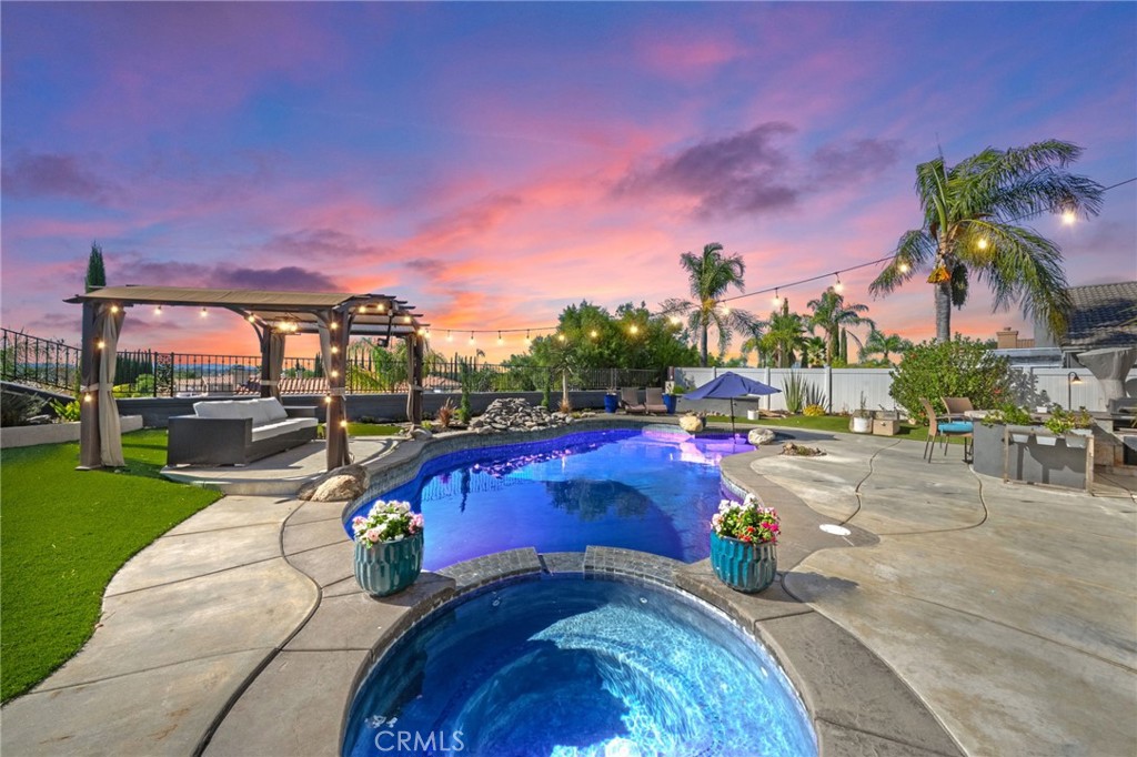 SOUTH TEMECULA POOL HOME WITH VIEWS! Nestled in the desirable Vail Ranch community within the highly sought-after Great Oak High School boundaries, this 4-bedroom beauty offers the perfect blend of lifestyle and location—just minutes from Temecula Wine Country, Old Town’s dining and entertainment, and Pechanga Resort & Casino. The thoughtful layout includes a main-level bedroom with double-door entry and a full bath, ideal for guests or multi-generational living. Easy-care tile and laminate flooring run throughout the first floor. The formal living room features charming built-in niches, while the separate dining room overlooks the sparkling pool and connects seamlessly to the kitchen. The open-concept kitchen boasts tile counters, stainless steel stove and built-in microwave, pantry, and barstool seating, flowing directly into the family room where a cozy fireplace, surround sound, and French doors to the backyard create the ultimate gathering space. Upstairs, the primary suite showcases two mirrored walk-in closets, dual sinks, and serene views of both the pool and surrounding mountains. A spacious loft offers endless possibilities—game room, theater, or home office with built-in desk and shelving. Two additional bedrooms and a full bath complete the upper level. Step outside to your private retreat featuring a sparkling pool, bubbling spa, BBQ island, artificial turf, and multiple seating areas—all framed by mountain views and low-maintenance vinyl and wrought iron fencing. Conveniently close to shopping, restaurants, Temecula Valley Hospital, and top-rated schools, this is the South Temecula lifestyle you’ve been waiting for. Don’t miss it—schedule your private tour today!