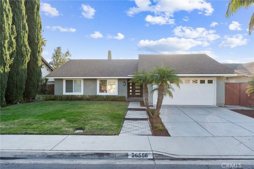 Welcome home to this beautiful, turn-key three-bedroom, two-bath, single-level ranch-style home in the heart of Mission Viejo. You'll be in awe of the attractive curb appeal when you arrive. The gorgeous front door beckons you inside. Once there, you'll be greeted with cathedral-style ceilings in the living room, a custom gas fireplace, elevated crown moldings, baseboards, and all-newer interior designer paint in a warm white, giving this residence a new look. The kitchen is light and bright with an updated natural stone backsplash, updated hardware, stainless appliances, a new gas range, and plenty of storage. In addition, there is an ample in kitchen eating space.  Just off the sliding door, you will be elated by the very private and spacious backyard, which boasts a covered patio and strung Bistro lights for ambiance during those warm evenings when dining outside. The primary bedroom features a remodeled bath with a beautiful walk-in shower and glass enclosure. For your convenience, there is a two-car direct access garage. The location of this property cannot be beat in central Mission Viejo. You are close to everything...shopping, entertainment, restaurants, and within walking distance of Montevideo Elementary School and El Dorado Park. In addition, if you want to enjoy the Mission Viejo lifestyle, you can take advantage of the MV Lake privileges that come with this home. This move-in ready and very inviting property is ready to welcome you!