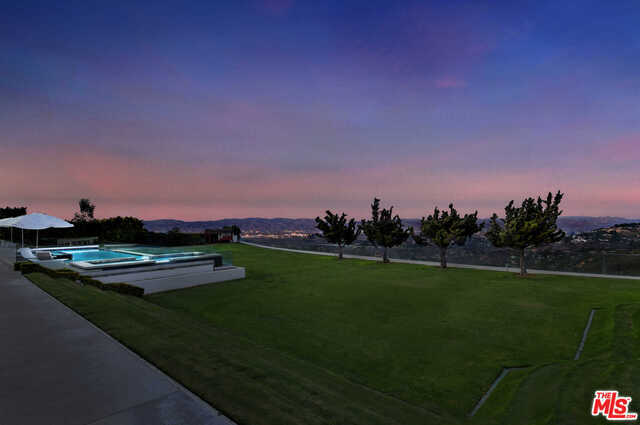 Indulge in the fine art of living. The most compelling architecture, designed by the hippest and cloistered in a secured guard-gated community. Breathtaking panoramic views. Voluminous space with floor to ceiling windows presents the most precious of art - the still life of purple-hued mountains and miles of valley life below. A shimmering pool interrupts the luscious soccer field of flat green grass. Inspiration. Innovation. Luxury. Have an Equinox experience in the 1500sf professional gym that offers private massage and sauna. Lighted North/South Tennis court amidst serene greenery. The house is a visual delight. It's a cozy and homey Museum of Modern Art. Revel in the confidence of these quality appointments and amenities, knowing that the hand of coveted tastemakers guided each and every unique aspect of this iconic home. The Master Suite invented the word "Wow" and the closets add the exclamation point! Welcome to a world of your imagination. Live like a Rock Star.