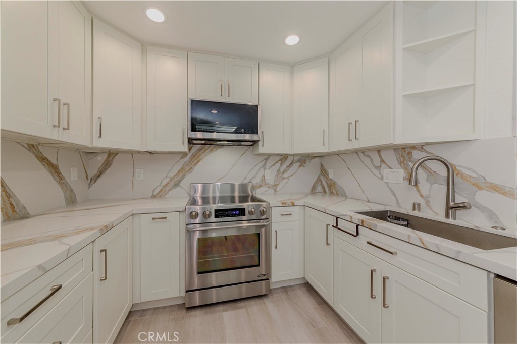 Welcome to this stylishly remodeled single-story condo in the gated Sea Spray community of Huntington Beach, where modern comfort meets coastal charm.
Offering turnkey living in a prime location, this meticulously updated 2-bedroom, 2-bath home is filled with natural light and features an open floor plan, soaring vaulted ceilings with exposed beams, custom paint, recessed lighting, plantation shutters and luxury vinyl flooring throughout. The inviting living room boasts a cozy fireplace and opens to a private balcony—perfect for morning coffee or evening relaxation.
The stunning kitchen showcases custom quartz countertops with matching backsplash and a waterfall-edge counter with bar seatings. Ceiling-height white shaker cabinetry provides ample storage, including a full wall of thoughtfully designed cabinets that offer creative workspace and enclosed shelving ideal for dinnerware collections. A deep undermount sink, stainless steel appliances, recessed lighting, built-in cabinet organizers, and a solar-powered deluxe skylight provide natural light and excellent air circulation, completing this gourmet kitchen.
Retreat to the oversized primary suite featuring a spacious walk-in closet and an en-suite bathroom with modern finishes and an airy skylight. The generously sized second bedroom also enjoys abundant natural light and a ceiling fan. Additional highlights include an in-unit laundry closet with washer, dryer and shelvings.
The home comes with one detached garage and one assigned parking space, plus EV charging and guest parking within the community.
Community amenities feature a recently updated pool and spa, lighted tennis courts, a clubhouse, lush greenbelts, and beautifully landscaped grounds.
Enjoy a prime location just across from Trader Joe’s and minutes to Huntington Beach, the Pier, and Main Street—the ultimate surfing and entertainment destination. Close to shopping, dining, parks, and scenic bike paths with easy access to the Santa Ana River Trail. Also conveniently located near Edison High School and Golden West College, with quick access to the 405 and 22 freeways—putting everyday essentials just minutes away.