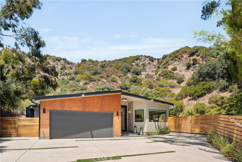 Tucked away in the hills of Encino, this beautifully updated home sits on a sprawling 30,000+ sf, gated flag lot that offers unparalleled privacy and seclusion with no direct neighbors behind you. As you enter the home you’re greeted to a light and airy open-concept floor plan highlighted by oversized sliding glass doors that seamlessly extend your living space outside. The spacious main living area consists of a sun-drenched living room, formal dining room with a temperature-controlled wine closet and gourmet chef’s kitchen outfitted with high-end Thermador appliances, a walk-in pantry and waterfall island with seating. Four generously sized ensuite bedrooms are spread throughout the home, each featuring a walk-in closet. The luxurious primary suite serves as a private sanctuary, complete with a large walk-in closet and spa-inspired bathroom showcasing a soaking tub, oversized rainfall shower, and double vanity. Designed with entertaining in mind, the resort-style backyard retreat boasts a sparkling pool/spa, fully equipped outdoor kitchen with bar seating, sunken fire pit and tiered deck that captures stunning vistas. Additional highlights include a dedicated laundry room, high ceilings throughout, built-in speakers, a security system, EV charger and two-car garage. Ideally situated South of the Boulevard in the highly sought-after Lanai Road School District, this exceptional property offers seamless access to both the Westside and the Valley.