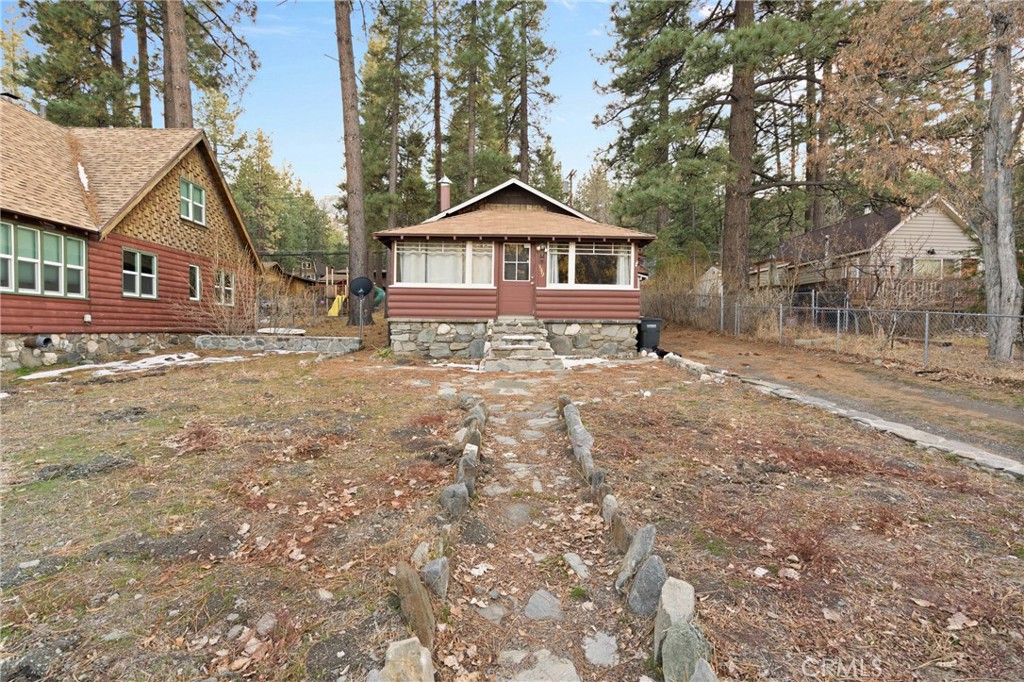 This iconic, original Wrightwood cabin is right across the street from the elementary school and a short distance to Mountain High ski resort. The living room offers front wrap vintage windows, wonderful wide plank pine paneling and a welcoming and warming stone fireplace. As you walk through the living room you enter the kitchen that has old school open cabinets. As you walk through the kitchen you enter a storage area and pantry. Here there is a door that leads to a mud room and laundry area with more storage cabinets. To the left is the bathroom. The two bedrooms finish off the living space.
The septic tank and system is approx one year old. The roof was replaced approx two years ago. It would make a wonderful Air B+B, a great weekend getaway or a very nice full time residence. The home is presently leased for 1590 per month.
Buyer to verify all information to their satisfaction. Owner is a licensed Real Estate Broker
