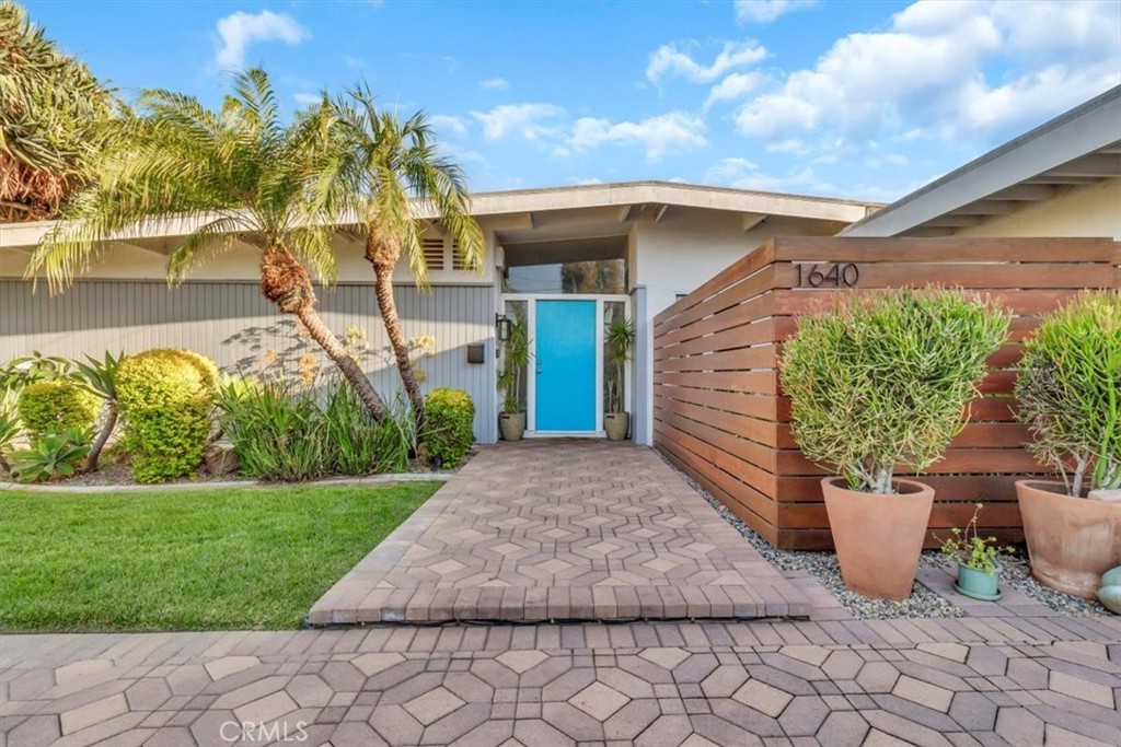 Modern Mid-Century Gem in the Heart of Orange County - Welcome to 1640 W Ricky Avenue, a beautifully upgraded 4-bedroom, 3-bath home located in one of Anaheim’s most desirable neighborhoods, just minutes from Disneyland and central to all that Orange County has to offer. From the moment you arrive, you’re greeted by a striking modern facade, lush tropical landscaping, and a beautifully laid circular paver driveway that allows for easy entry and exit and provides extra space for parking. Step inside to an expansive “open concept” living space filled with natural light, stylish finishes, and rich laminate wood plank flooring. The gourmet kitchen is a chef’s dream, featuring designer tile flooring, quartz countertops, stainless steel appliances, and a sleek tile backsplash. The adjacent dining area and multiple living spaces are perfect for entertaining or relaxing in comfort. The home features a tranquil sitting area that opens to a private Zen Garden, your own peaceful escape within the home. All three bathrooms have been tastefully updated. The guest and primary bathrooms feature quartz countertops with dual sinks. The guest bathroom offers a contemporary tub and shower combination, while the luxurious primary bath showcases a walk-in glass-tiled shower and a glass window overlooking a private garden, bringing the feeling of outdoor serenity indoors. The third bathroom is also fully updated and designed with quality and comfort in mind. Retreat to the resort-style backyard, a true oasis with a sparkling pool, shaded patio, mature tropical landscaping, and a built-in fire pit for cozy evenings outdoors. This home was remodeled in 2017/2018. There are 2 water heaters, 1 is 18 months old and the other is 6 years old. The entire house has new ABS Plumbing. Additional features include a spacious two-car garage, an indoor laundry area, recessed lighting throughout the home, solar panels, and location within a quiet, well-maintained neighborhood. This home blends timeless mid-century design with modern updates in a prime Anaheim location, three Miles from Disneyland. Whether you're entertaining guests or enjoying a quiet evening in your backyard paradise, 1640 W Ricky Avenue offers the perfect balance of comfort and style.