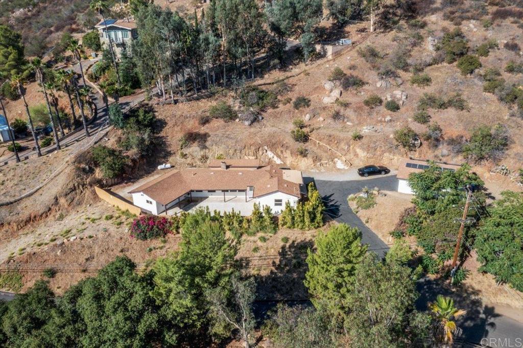 Welcome to Your Eucalyptus Hills! Just Minutes from Poway & Santee! Tucked away on nearly an acre in the highly desirable Eucalyptus Hills neighborhood, this home offers more than just a place to live—it’s a lifestyle. Imagine sipping your morning coffee while taking in breathtaking views, or enjoying peaceful evenings surrounded by nature. Inside, you’ll find two primary bedrooms, perfect for privacy and flexibility. One even offers direct access to the front porch—an inviting space to step out, relax, and soak up the fresh hillside air. This property also comes fully equipped with 19 paid solar panels plus battery backup, a 250-gallon propane tank, and a new septic system (installed in 2020)—giving you peace of mind and efficiency for years to come. Stay comfortable year-round with central heating and air conditioning, and enjoy the convenience of all appliances and smart TVs conveying with the home. The oversized two-car garage opens up endless possibilities—convert it into an ADU for guests or extra income, or dream bigger by adding a second story to capture even more of the stunning hillside views (buyer to verify permits). Set on 0.88 acres, this property blends the charm of country living with modern conveniences, making it the perfect backdrop for your next chapter. Room to grow. Space to breathe. Views to inspire.