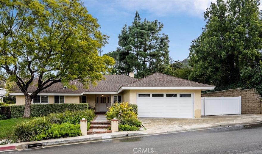 Welcome to this beautifully updated home, ideally located south of the Boulevard in the serene hills of Studio City. Enter into a grand formal living and dining room that boasts vaulted, wood-beamed ceilings and a cozy fireplace. At the heart of the home, the gourmet eat-in kitchen, outfitted with top-of-the-line appliances, opens seamlessly to the spacious family room. The primary suite offers two walk-in closets and a well-appointed bathroom, complete with a soaking tub, large shower and double vanity. Additionally, there are two bedrooms and a spacious enclosed loft that can be utilized as a bedroom, office or bonus space. Three sets of french doors lead out to a tranquil backyard oasis, perfect for entertaining. Take a refreshing dip in the sparkling pool/spa or lounge around on the expansive patio. There’s also a large side yard that can be used as an additional area to entertain or store a vehicle. Further amenities include a dedicated laundry room, skylights throughout and a two-car garage.