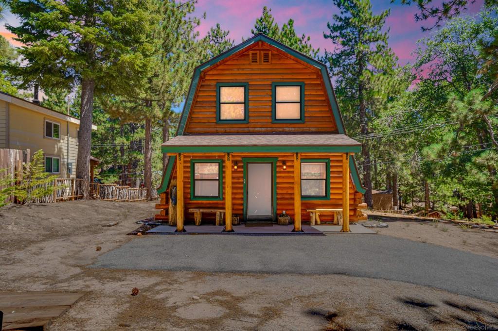 Looking for the perfect log cabin? Look no further! This charming 2+2 cabin is bright and inviting, featuring stunning high ceilings and beautiful tongue-and-groove knotty pine throughout. The main level boasts a cozy living room with a freestanding wood-burning fireplace, an upgraded kitchen with high-end appliances, a porcelain double sink, tile countertops, and a wine refrigerator. You'll also find a bedroom, a fully upgraded bathroom, and a laundry area with washer and dryer hookups, plus a door leading to a lovely porch. ** A natural log staircase ascends to a spacious master loft retreat, complete with a full bathroom, a seating area, and a private viewing deck. The cabin is equipped with new light fixtures, ceiling fans, central heating, six skylights, and double-pane windows. Situated on a well-maintained corner lot with a paved driveway and storage shed, this property is ideally located for outdoor enthusiasts, with hiking, fishing, and snowboarding just minutes away. This immaculate cabin is truly move-in ready and offers a wonderful mountain retreat. **