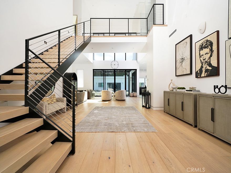 SELLER FINANCING MAY BE AVAILABLE!  A Modern Masterpiece of Luxury Living. Nestled at the end of a quiet cul-de-sac in an exclusive neighborhood, this 2021-built estate offers unmatched luxury and stunning views. Set on a 21,000 sq ft elevated lot, the home spans approximately 5000 sq ft and boasts exceptional craftsmanship, sleek design, and high-end finishes throughout. Step into the grand foyer with soaring 27-foot ceilings and a floating staircase leading to the open-concept Great Room, featuring walls of glass, telescoping doors, and French oak hardwood floors. The chef’s kitchen is equipped with dual-waterfall islands, Thermador appliances, custom cabinetry, and a separate prep kitchen. A private office, guest suite, and powder room are located on the main level. The luxurious primary suite offers panoramic views, a private terrace, and a spa-like bathroom with designer tiles, freestanding tub, and dual walk-in closets. Two additional en-suite bedrooms are tucked away in a separate wing for added privacy. The resort-style backyard includes a pool, spa, fireplace, built-in BBQ, fire pit, and putting green, making it perfect for entertaining. A detached guest house with a full kitchen, living room, two bedrooms, and a bath offers 2,000 sq ft of additional space (making 7000 sqft total), ideal for guests or multi-generational living. This modern estate combines unparalleled luxury with the ultimate in comfort and style, offering an extraordinary lifestyle.