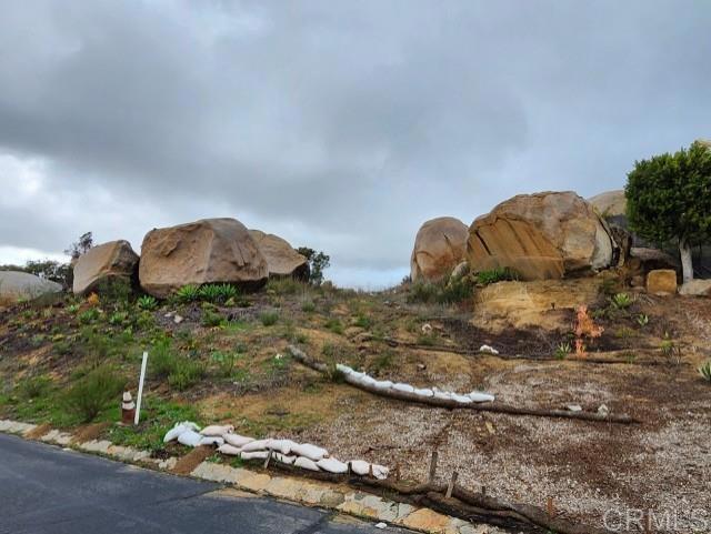 Massive boulders frame the majestic gateway to your future castle. Arguably one of the best lots in Rimrock, this .89-acre parcel in the exclusive gated community of Rimrock Estates offers the perfect canvas to build your dream home. Immerse yourself in breathtaking views that stretch from the surrounding mountains and valleys to the distant ocean. Experience luxury living at its finest. Experience the perfect balance of privacy and convenience! Enjoy serene living while being just moments away from Highway 15, top restaurants, shopping, the beach, downtown, and everything San Diego has to offer. The developer is known for building on and around massive boulders and is offering a unique opportunity. The property is available for sale as is, or you can enter into a construction contract. With years of experience in the industry, he is ready to help design and build your perfect home. Ready to grade with utilities at street. Sewer and city water.