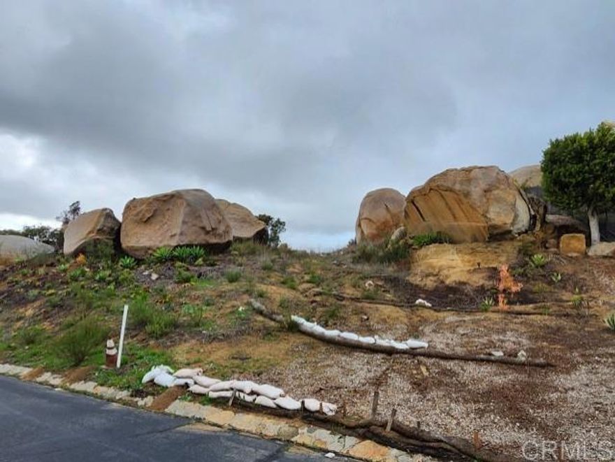 Massive boulders frame the majestic gateway to your future castle. Arguably one of the best lots in Rimrock, this .89-acre parcel in the exclusive gated community of Rimrock Estates offers the perfect canvas to build your dream home. Immerse yourself in breathtaking views that stretch from the surrounding mountains and valleys to the distant ocean. Experience luxury living at its finest. Experience the perfect balance of privacy and convenience! Enjoy serene living while being just moments away from Highway 15, top restaurants, shopping, the beach, downtown, and everything San Diego has to offer. The developer is known for building on and around massive boulders and is offering a unique opportunity. The property is available for sale as is, or you can enter into a construction contract. With years of experience in the industry, he is ready to help design and build your perfect home.  Ready to grade with utilities at street. Sewer and city water.