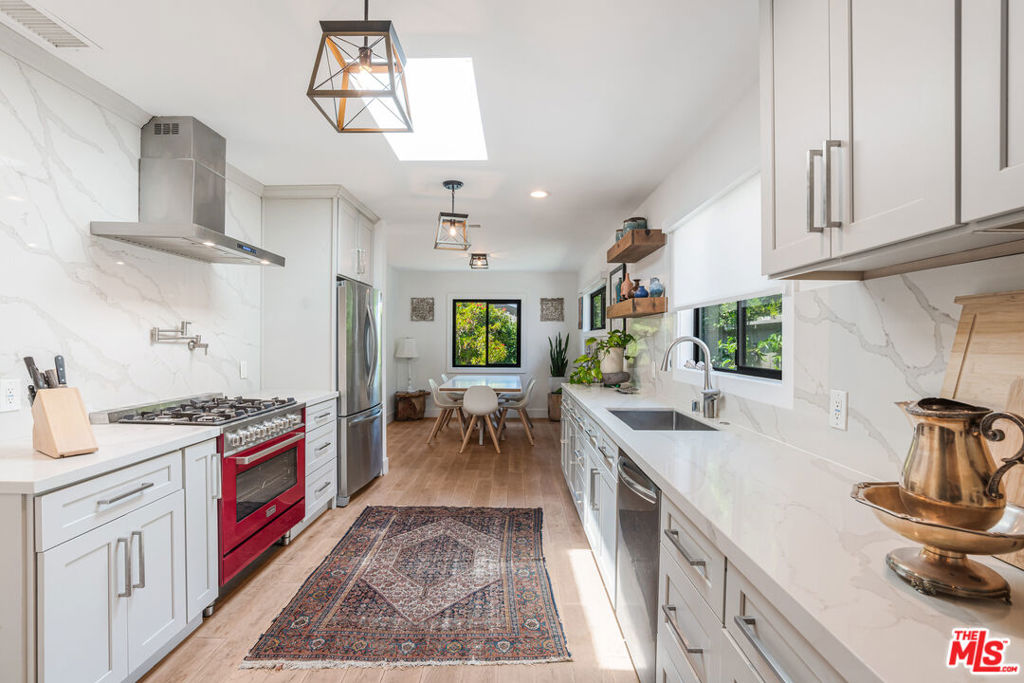 Step into this stunning modern Venice farmhouse, a rare gem just moments from Abbot Kinney, Lincoln Boulevard hotspots, and the beach. Gated and beautifully landscaped, the spacious front and back yards offer a private oasis perfect for kids, pets, and entertaining, complete with an amazing garden full of fruit trees and a dedicated outdoor shower for that quintessential beach lifestyle. Enjoy al fresco dining and lounging under the stylish outdoor seating area, which features pullable shades for comfort and privacy. Inside, natural light pours through dual skylights and oversized windows, highlighting the home's impeccable finishes. The open-concept chef's kitchen is a true showstopper with custom Calacatta quartz countertops, a 36" Verona range with pot filler, and a 100-plus bottle dual-zone wine cellar ideal for the discerning entertainer. Retreat to the serene primary suite featuring his and hers custom closets and a spa-like Carrara marble en suite bath. Bonus alert: the fully finished detached bonus room with vaulted ceilings and windows adds 400 square feet of versatile space. Use it as an office, gym, guest suite, or creative studio. Thoughtfully designed living space with modern upgrades, including a newer roof (2017), central heat, and AC. This one checks all the boxes with space, style, and an unbeatable Venice location.
