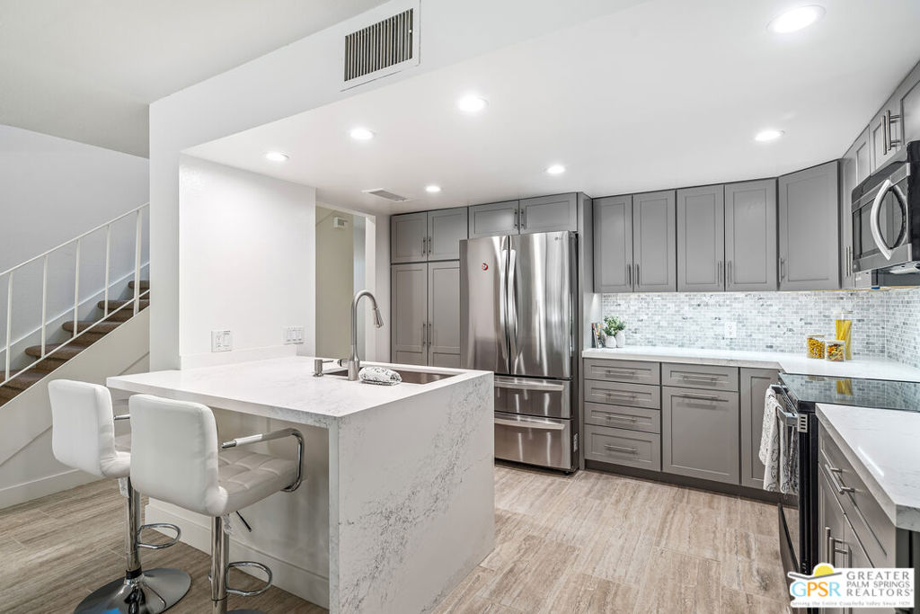This exceptional South Palm Springs condo, DESIGNED BY RENOWNED ARCHITECT HUGH M. KAPTUR, is NOW AVAILABLE FOR LEASE and offers a seamless blend of mid-century modern design with contemporary comfort. Expansive sliders frame BREATHTAKING SAN JACINTO MOUNTAIN VIEWS, while sleek lines and sophisticated decor create a warm, inviting atmosphere. Inside, TWO PRIMARY ENSUITES provide space and privacy, one featuring a fireplace, spectacular mountain views, and a private balcony. The living area, centered around a fireplace, opens effortlessly to a LARGE PATIO OVERLOOKING THE POOL AND LUSH LANDSCAPE perfect for relaxation or entertaining. An attached garage with ample storage, in-unit laundry, and a DOWNSTAIRS BATHROOM complete with a shower enhance convenience, making this residence ideal as either a full-time retreat or seasonal getaway.Set within a gated community offering RESORT-STYLE AMENITIESincluding two POOLS, two SPAS, TENNIS COURTS, a CLUBHOUSE with a FITNESS ROOM, and citrus-lined greenbeltsthis home is just moments from the best dining, shopping, and outdoor recreation in Palm Springs. A rare opportunity to LEASE a slice of Palm Springs luxury in a prime location!