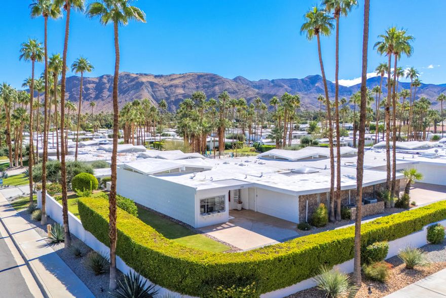 Here's a rare opportunity to own in this coveted and intimate 14-unit enclave, and final phase of William Krisel's iconic Canyon View Estates. Condos in this HOA rarely come on the market. This end unit offers one of the largest floor plans in Canyon View Estates with just under 2,000 square feet of living space, and a two-car garage. For modernism enthusiast, some original features remain. Highlights include the iconic pop-up umbrella roofline with triangular clerestory windows on four sides providing 360-degree views and an abundance of natural light. A double door entry with original iron gates leads to a spacious foyer. The layout includes a large living/dining room, expansive primary bedroom, a generous second bedroom, a den (3rd bedroom) with a wet bar, and two bathrooms with original terrazzo floors, with the primary bath featuring a roman style tub. The expanded kitchen has been updated with a built-in office area with west facing views. There is also interior laundry, and easy access to the private resort style community pool and spa. Enjoy expansive views from the covered patio along with misters to keep cool. Recent 2025 upgrades include a recoated foam roof and resealed clerestory windows.Completed in the late 1960s, Canyon View Estates HOA #7 is located behind a beautiful hedgerow in its own enclosed private enclave set apart from neighboring associations. Situated on a rise, these homes offer spectacular patio views above neighbors to the east and across Indian Canyons towards Southridge and the famed Bob Hope house, as well as south towards the beautiful Andreas Hills. Architectural touches such as native stone, breezeblock inserts, and patterned concrete shadow block highlight the timeless mid-century style. Several homes within Canyon View Estates HOA#7 have opened their doors to Modernism Week tours since 2022, offering mid-century modern enthusiasts a peek inside these classic residences.