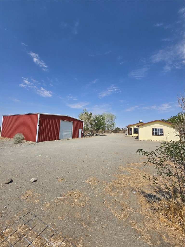 Discover this versatile home nestled on approximately 2.1 acres in the desirable Pinon Hills community of San Bernardino County. Set on a permanent foundation, this impressive property offers a 40' x 40' Forbes metal building on a concrete slab with dual roll-up doors — perfect for hobbies, a workshop, or extra storage — plus an attached 3-car garage for all your vehicles and toys. Enjoy energy efficiency and savings with an owned solar system, individual septic systems, a dedicated propane tank, central air and heating, and a cozy wood-burning stove. A huge, permitted 37' sunroom extends your living space to soak in the serene surroundings year-round. Secluded yet conveniently located near paved Bear Valley Rd and just minutes from the 15 and 215 freeways, you’ll also appreciate access to highly rated schools in the Snowline Unified School District. This one-of-a-kind property is ready to become your private retreat — come make it your home!