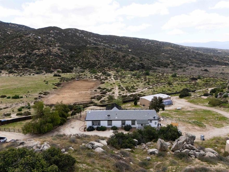 Welcome to Lewis Valley – Your Private 40-Acre Ranch Retreat in the Hills of Hemet. If you’re seeking serenity, privacy, and wide-open spaces, this property in Lewis Valley is a rare opportunity to own your own 40-acre ranch surrounded by rolling hills and breathtaking views. Property Features:  Peaceful, secluded, and tucked away off a dirt road with no street noise. 2,400 Sq. Ft. Manufactured Home – Recently remodeled with 3 bedrooms, 2 full baths, a spacious living room with vaulted ceilings, and an additional 600 Sq. Ft. bonus family room. Updated Interior Finishes – Luxury vinyl plank flooring, new kitchen with updated cabinetry, counters, and hardware, fresh baseboards, and large dual-pane windows bringing in natural light and framing scenic views. Primary Suite – Private bath with a walk-in shower, soaking tub, dual sinks, and ample storage. Generous Guest Bedrooms – Spacious with picturesque views of the surrounding hills. Interior Laundry Room – Convenient and functional. Outdoor Living: Expansive View Deck – The perfect place to unwind and enjoy the gentle breezes and snow-capped mountains in the distance. Private Well & Pressure Tank – Providing your own water source. Newer Roof – Installed in 2007 for peace of mind. Ceiling Fans Throughout – Adding comfort year-round. Workshop / Detached Building: 60' x 30' Steel Building – A versatile space with electricity, water, and a separate septic system. Two Finished Rooms & Kitchenette – Ideal for a guest suite, office, or studio. Large Workshop / Warehouse Area – With roll-up doors and separate access driveway — perfect for RV storage, car enthusiasts, or agricultural use. Conex Container Included. Additional Highlights: Multiple Rough Pads – Ready for expansion, additional buildings, or potential future projects. Unmatched Privacy – Enjoy a tranquil setting without neighbors in sight. This is truly a special property offering a unique blend of rural living, privacy, and potential — ideal for ranchers, hobbyists, or anyone looking to escape the hustle and bustle. Take the back roads to Palm Desert or Temecula for some wine tasting.  Bring your horses, chickens and sport utility vehicles.   Schedule your private showing today and explore all the possibilities this 40-acre ranch has to offer!