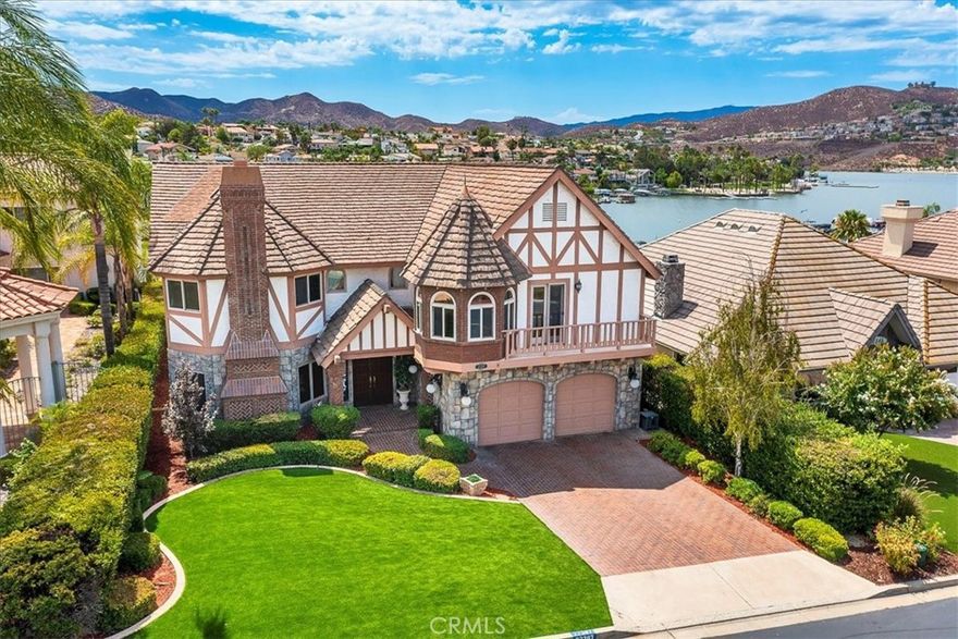 Absolute best location on the lake! A CASTLE five doors down from the Lodge and Lighthouse restaurant! Some of the best lake views in Canyon Lake including perfect views from any of your three decks of the Canyon Lake’s famous July 4th fireworks show. One of the largest WATERFRONT lots in Canyon Lake. The lodge and all its amenities (junior Olympic size pool, restaurant & bar, tennis courts) are just steps away. When Fiesta Days comes back you will be right in the middle of the fun. Located on Holiday Bay, you're near the activity but away from the wakes and have a PANORAMIC VIEW OF THE MAIN LAKE. At the water's edge is a new BOAT DOCK. This is a true very custom Tudor style home with extensive use of brick and woodwork. All the rooms are large, and the flowing floor plan has no wasted space. The formal dining room will hold your largest gathering and features hidden storage for your finest China and crystal. The kitchen is open to the family room and features custom granite counters, a walk-in pantry, and newer appliances. The family room has a wet bar complete with beer on tap. You'll never want to leave the luxurious primary suite, as it takes full advantage of the lake views. Just some of the features you'll find in this suite are dual, walk-in, cedar closets, counters and sinks for two, and separate walk-in shower. In addition to the 3 generous bedrooms there is a large office with custom built-ins. The bath between the bedrooms features a SAUNA & a steam shower. You'll appreciate the convenience of the upstairs utility room with folding counters, sewing area, built-in ironing board and more. Beautiful chandeliers adorn the home in several rooms. The entry chandelier actually lowers to change bulbs! You'll find several custom ceilings, one hand painted. The backyard has a PUTTING GREEN. The brick walkways in the rear lead you to an extra large entertaining deck, featuring a multi purpose room underneath with double doors. It's perfect for all those lake toys or an exercise room. In addition to all these features, there is ample protected parking in the tandem 4 car garage. Don't miss this one of a kind property!