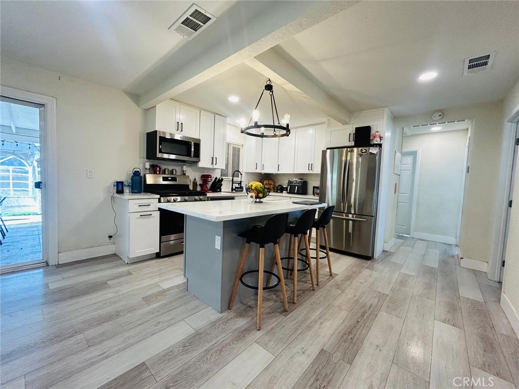 Single-story home 3 Bedrooms, 1 Bathroom, completely remodeled! Covered patio & LARGE backyard! Step into an open-concept kitchen featuring recessed lighting and new wood laminate flooring throughout... Modern kitchen w/brand-new cabinets, granite countertops, an island, and newer appliances, including a stove-oven range, microwave, and dishwasher. Bathroom has been remodeled with a walk-in tile shower; Spacious and individual laundry room! Newer central A/C, heater, windows, including a newer water heater. LARGE LOT WITH PLENTY OF SPACE IN THE BACKYARD TO BUILD A POOL, AN ADU OR TWO! Easy access to Freeways 91/215/60 interchange. Turnkey home ready for the next family!