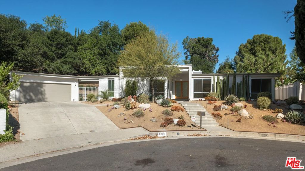 Experience elevated California living in this architecturally striking mid-century modern residence, perfectly situated at the edge of the San Fernando Valley, where Woodland Hills meets the natural beauty of the Santa Monica Mountains. Offering four spacious bedrooms and three and a half baths across 2,806 square feet, this home is a rare blend of iconic design, serene surroundings, and modern convenience. At the end of a cul-de-sac, this wonderful home is beautifully landscaped with native, drought tolerant plants. Step into an expansive, light-filled interior with high ceilings and dramatic, oversized sliding glass doors that create a seamless connection to the outdoors. The open-concept living space provides a flexible function and designed for both refined entertaining and everyday comfort, with lightly colored hardwood flooring throughout and clean, contemporary lines that honor the home's mid-century roots. The chef's kitchen features sleek quartz countertops, stainless steel appliances, and custom cabinetry ideal for those who appreciate both form and function. Outside, the oversized 24,541 sq ft lot offers an extraordinary level of privacy. A sparkling pool is the centerpiece of the beautifully landscaped, flat backyard which is also filled with mature trees surrounding the perimeter- an ideal setting for relaxation, al fresco dining, or weekend gatherings. Enjoy the convenience of being moments from award winning public schools, Viewpoint School, Louisville High School, premier shopping and dining, while also having quick access to hiking trails and just a short, scenic drive over Topanga Canyon to the beaches of Malibu. This is luxury leasing for those who value design, nature, and lifestyle in equal measure. *Photos with furnishings are virtually staged*