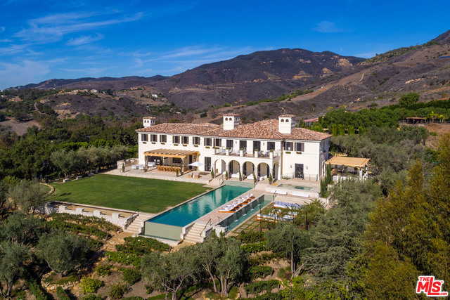 Inspired by Mediterranean country estates and homes from the South of France, La Vie en Rose was crafted to integrate seamlessly into the hillside with 270-degree views of rolling hills and the ocean. Ascend a lavender lined gated drive, pass trussed vining roses and mature olive trees to a 10-car circular motor court and the 2-story ocean view home with vintage pavers, French oak floors, mahogany doors and hand-troweled plaster walls. Enter the grand 2-story double-winding staircase entry to a formal living room w/fireplace, dining room, study and a chef's island kitchen that continues into a large family rm with fireplace - all opening to an expansive covered trellised patio and apx 2.7 acres of impeccably landscaped grounds with 75' waterfall infinity resort pool, N/S lighted tennis court, bocce court and multiple sitting areas for outdoor entertaining. The apx 1,750 sqft, 2nd level private ocean view owner's suite with 2-fireplaces, has 2-luxurious baths/closets and private deck.
